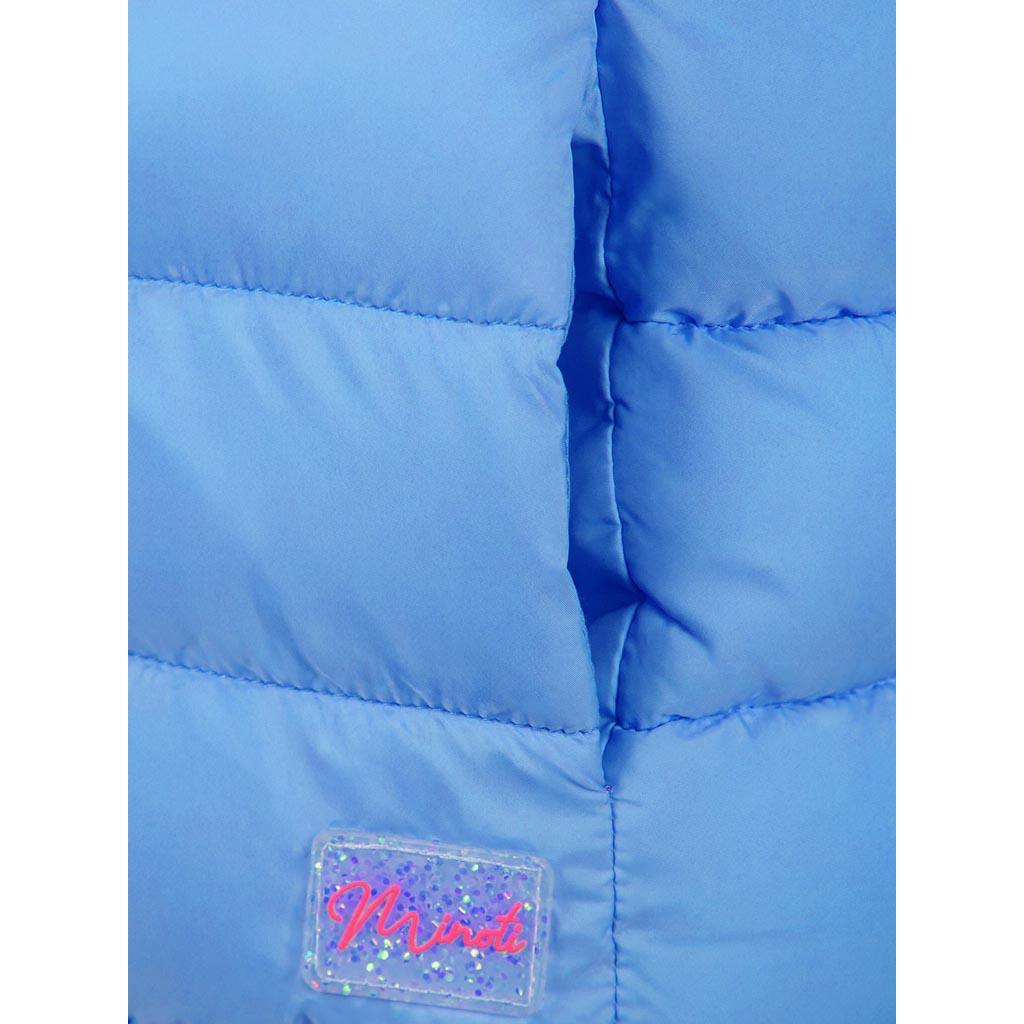 Close-up detail of light blue quilted gilet showing front zip, quilted texture, and snap button on chest pocket area