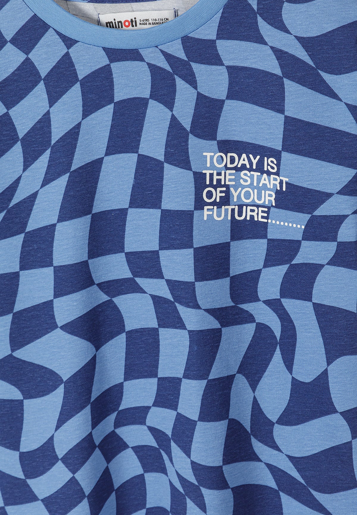 Close-up detail of blue and navy checkered pattern t-shirt with white text Today is the start of your future showing Minoti label