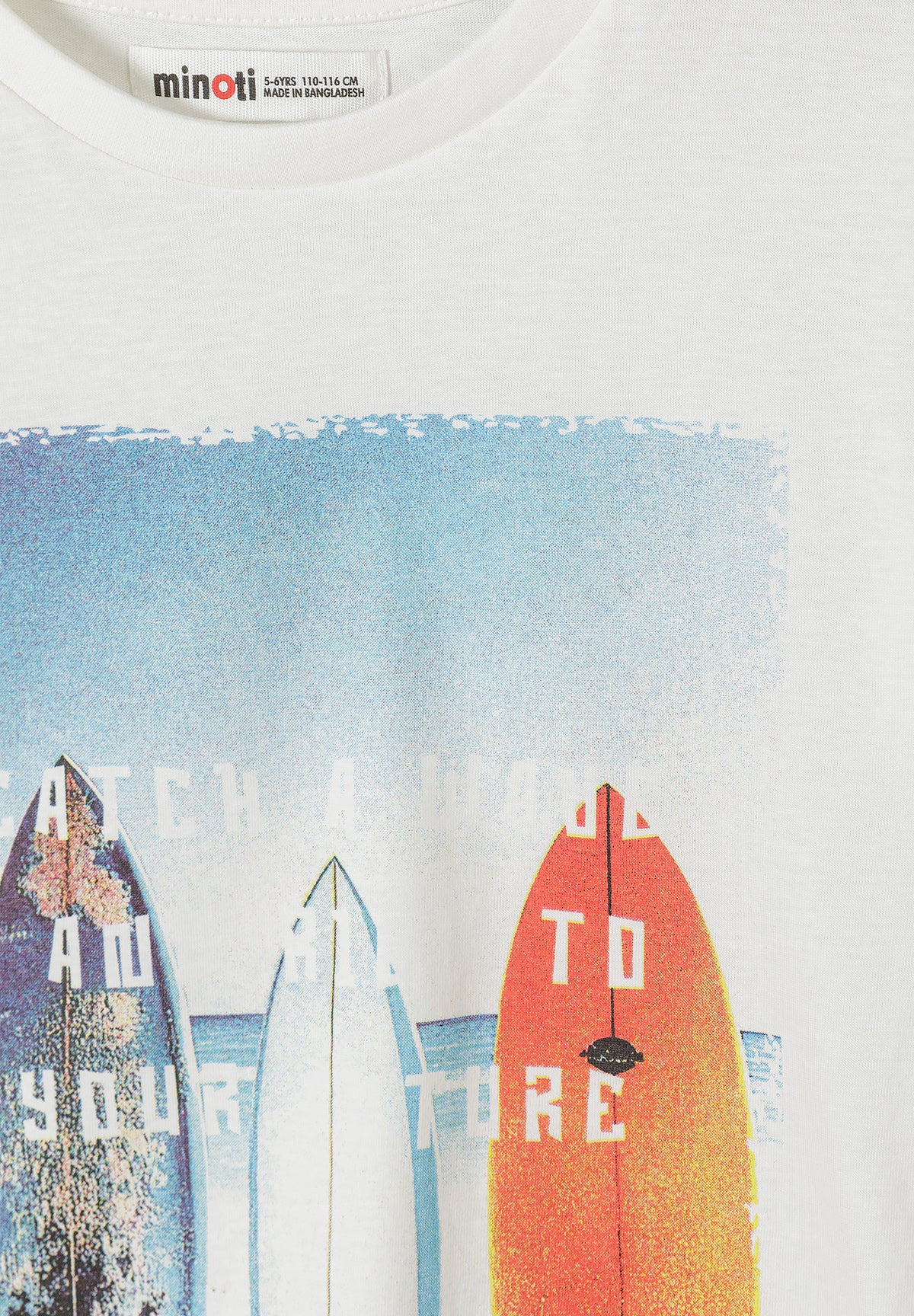 Close-up detail of white t-shirt showing palm tree and geometric pattern print with sun, waves, triangular shapes and spiral motifs in sage green color