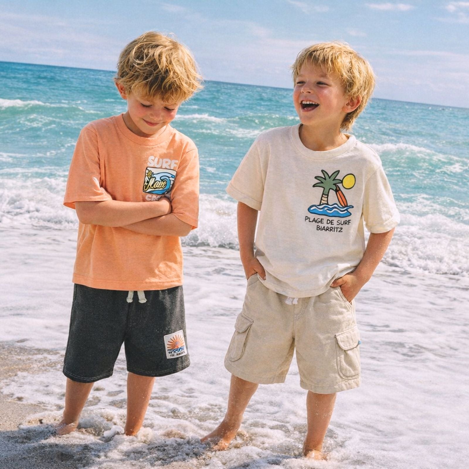 Two children standing on a beach with ocean waves in the background