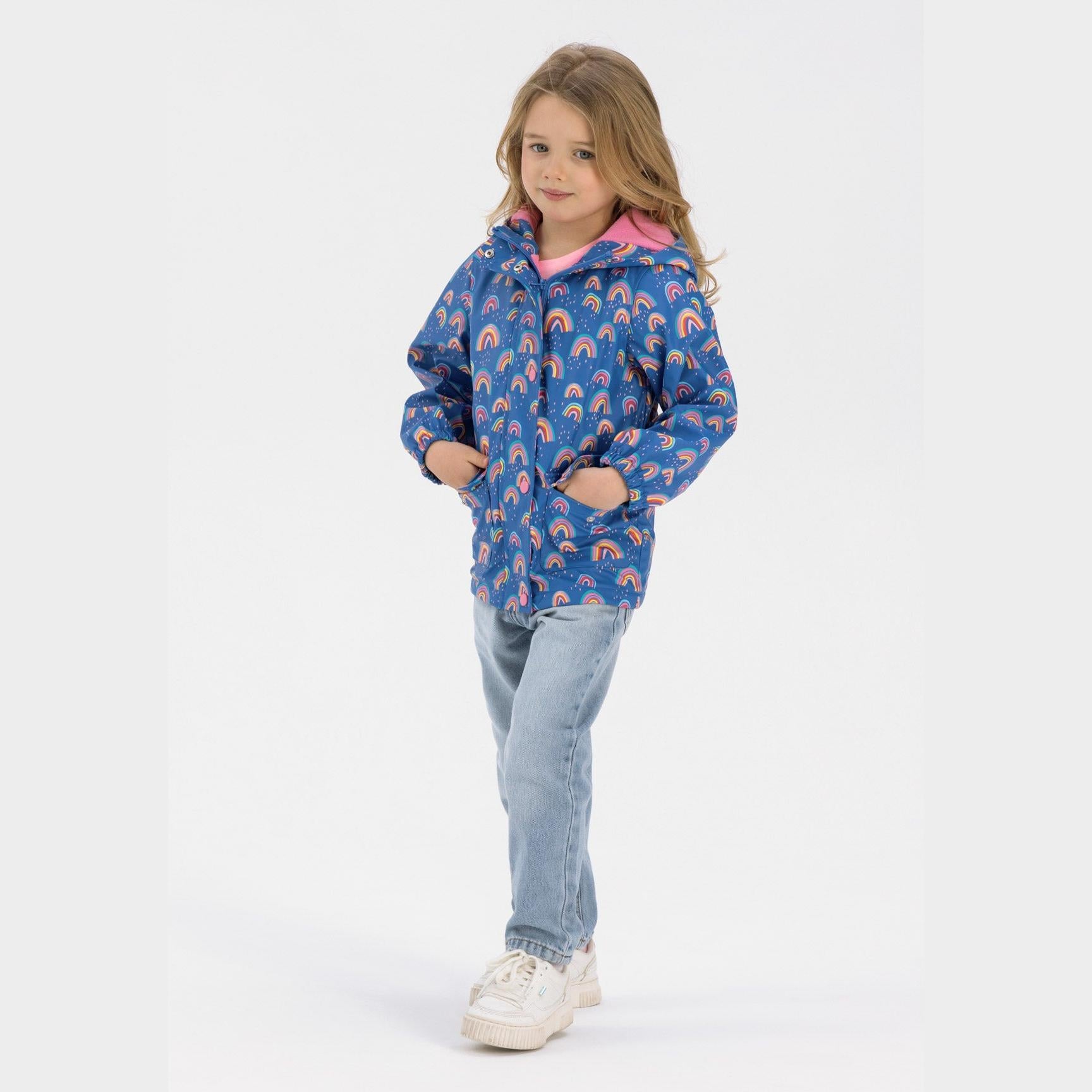 Back view of cobalt blue rain jacket showing rainbow print pattern and hooded design with elastic gathered hem on white background