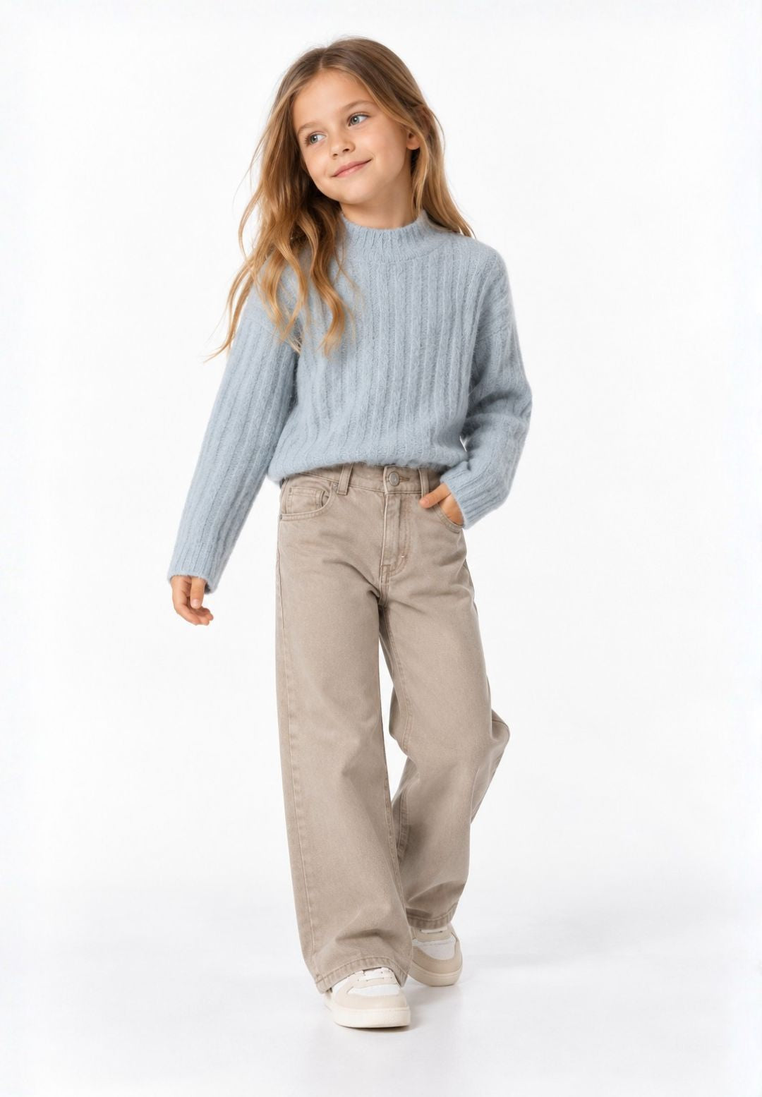 Girl wearing light beige wide-leg trousers with a light blue ribbed jumper and white trainers