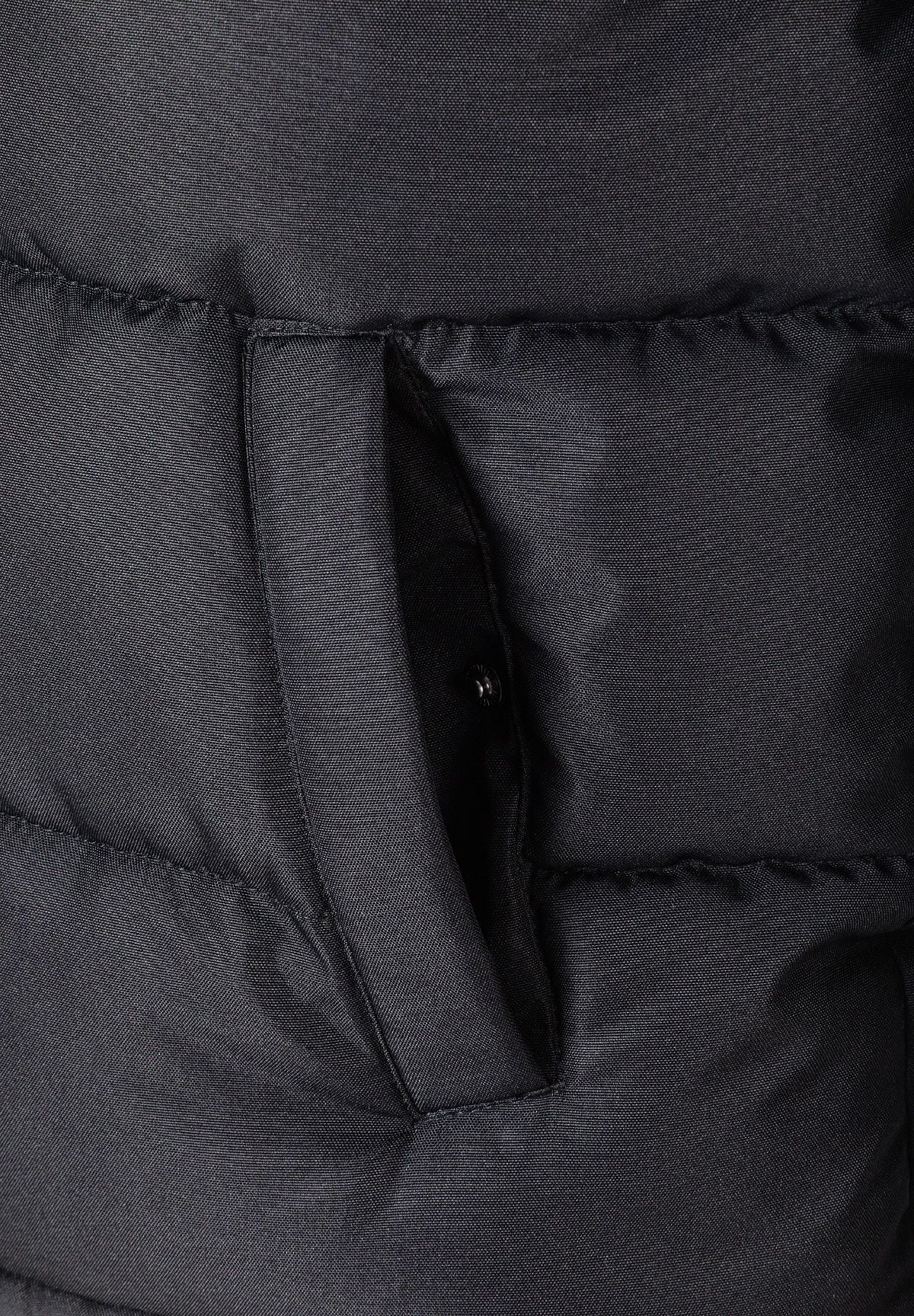 Detail of a black padded jacket showing a zip pocket and quilted texture.
