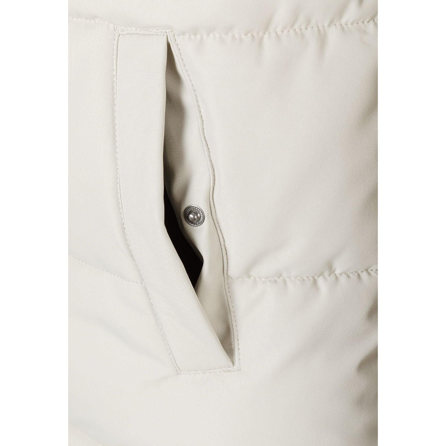 Close-up detail of grey padded jacket showing chest zip pocket, quilted texture and faux fur hood trim