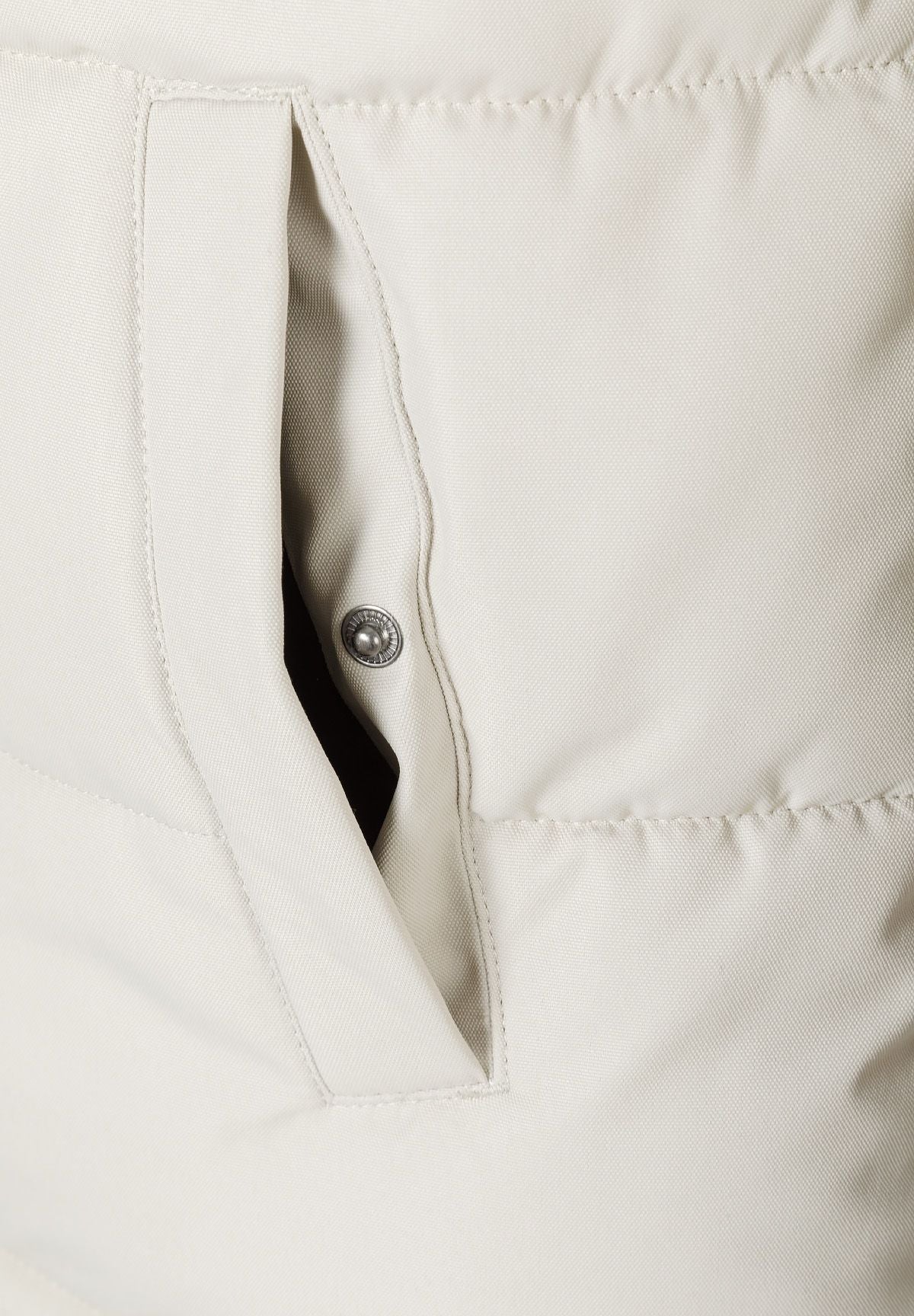Detail of a men's padded jacket showing a zippered pocket and button snap.