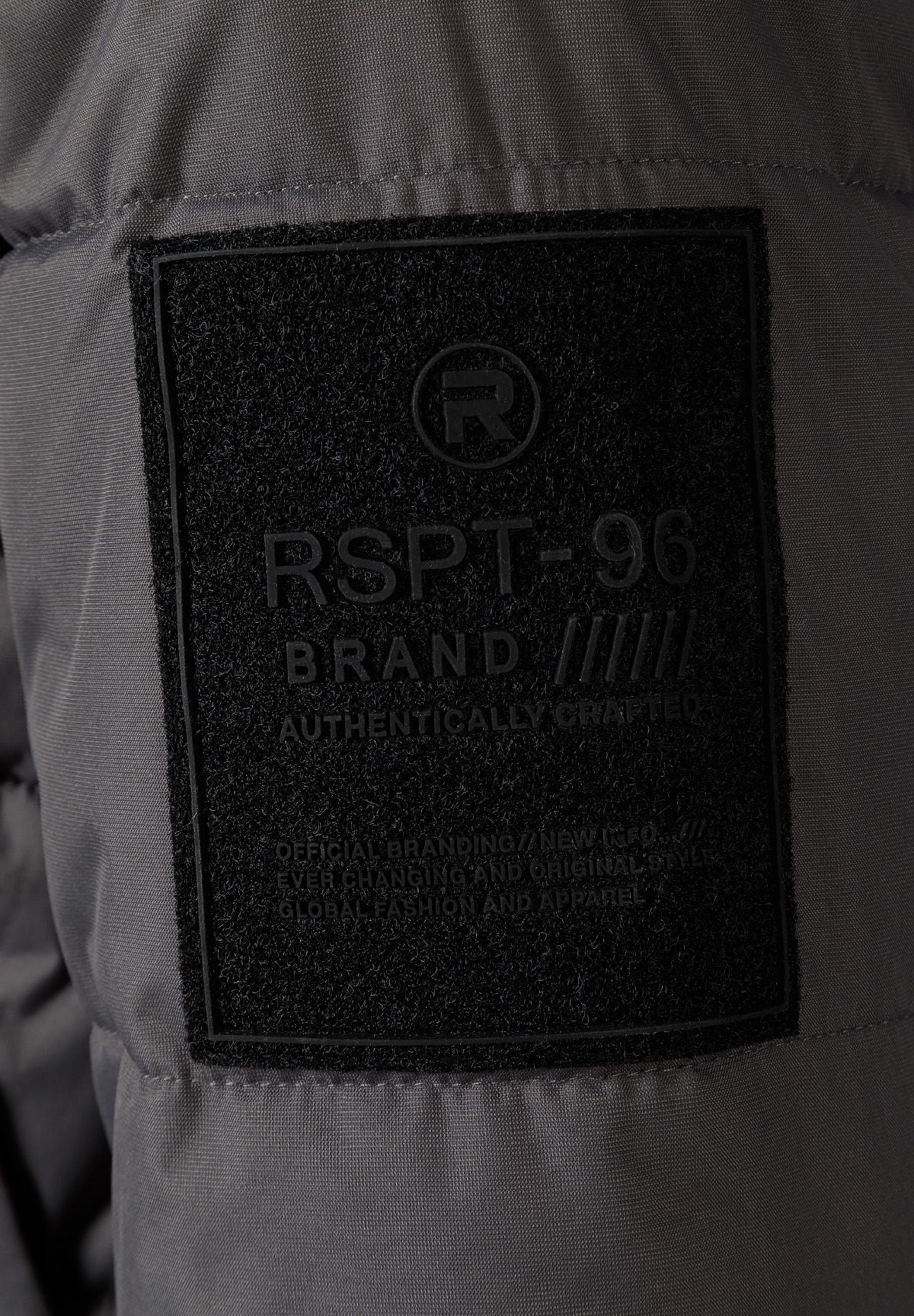 Detail of a grey padded jacket showing a logo badge on the sleeve.