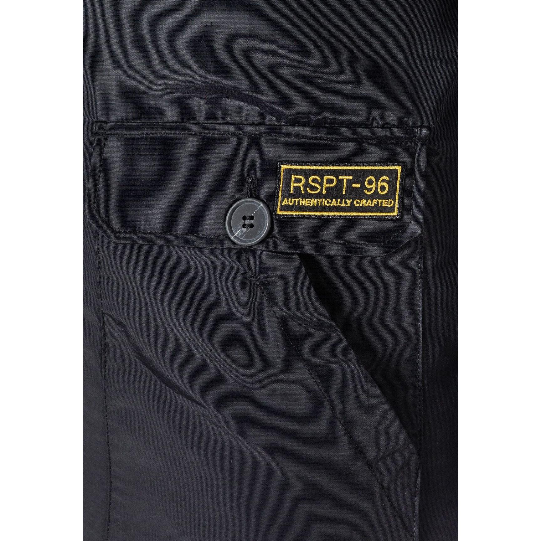 Close-up detail of black jacket pocket with RSPT-96 authentically crafted yellow embroidered patch and button closure