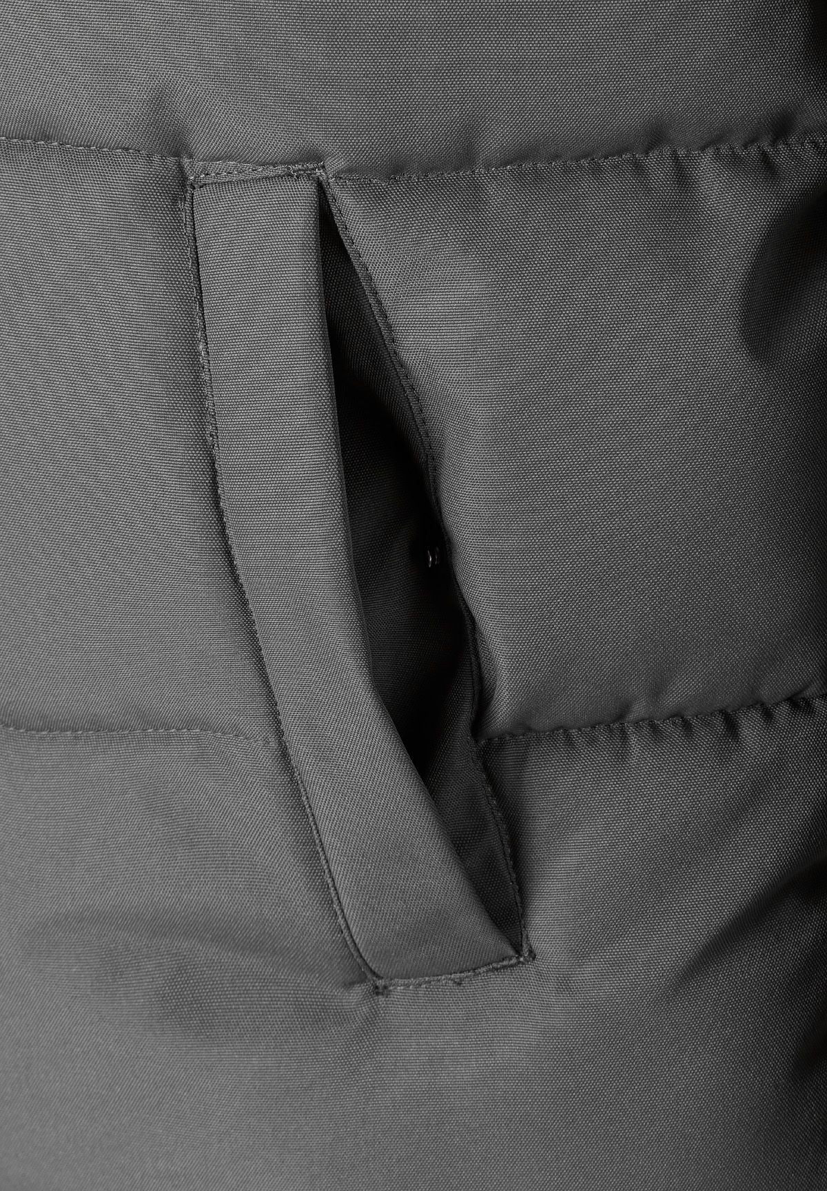 Detail of a men's padded jacket in grey, showing a zip chest pocket.