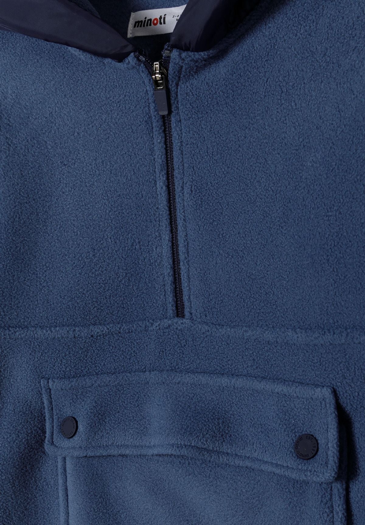 Close-up of blue fleece hoodie's quarter zip and two-snap front pocket flap.