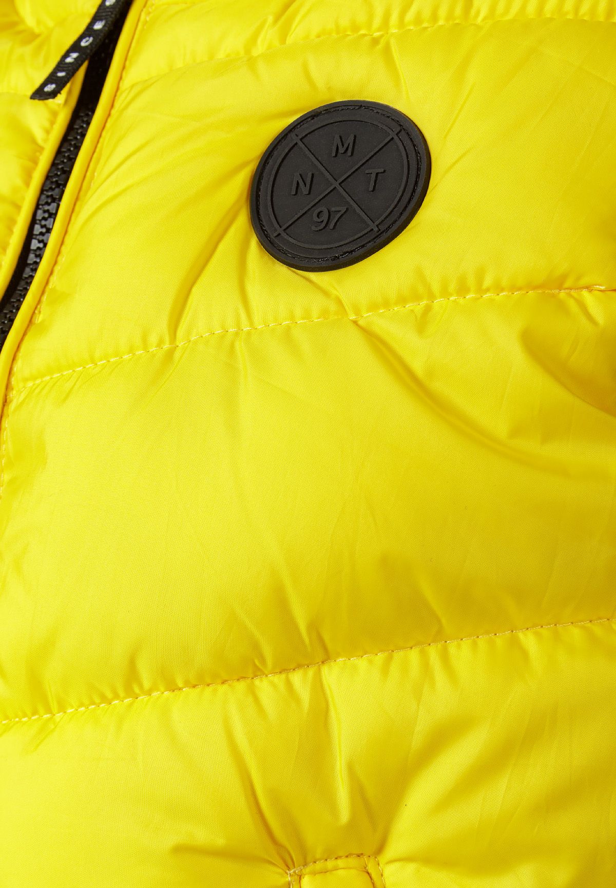Detail of boys padded gilet in yellow with chest badge.