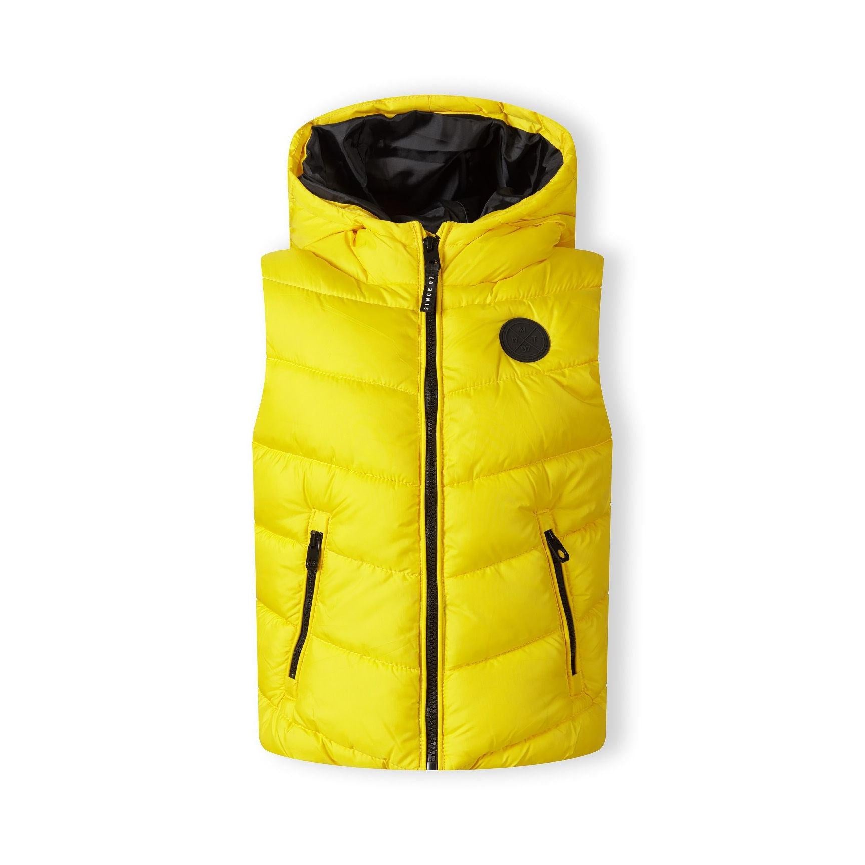 Yellow padded gilet laid flat showing front zip, black hood lining, chest badge and zip pockets against white background