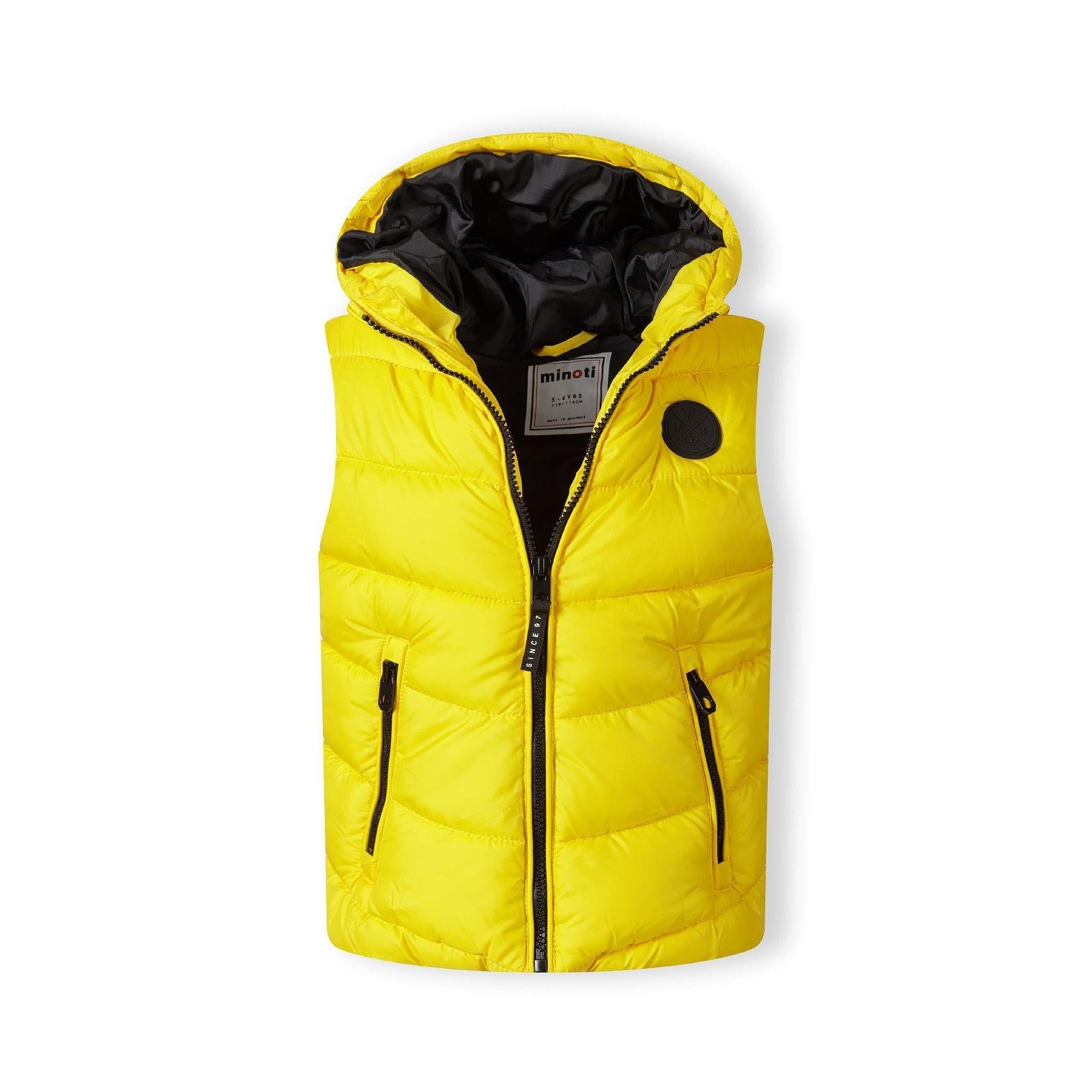 Yellow padded gilet laid flat showing front zip, black hood lining, chest badge and zip pockets against white background