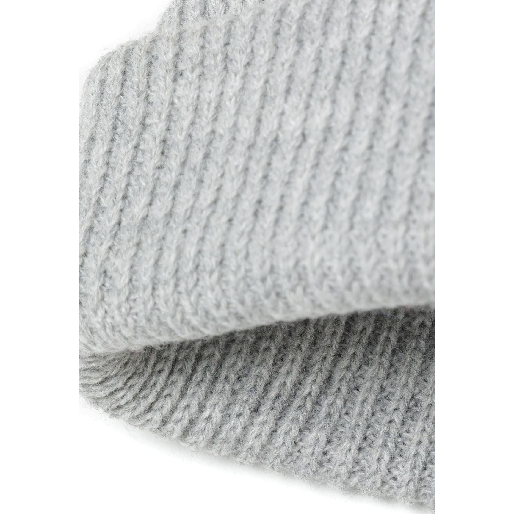 Side angle close-up of light grey ribbed beanie showing knit texture and folded cuff detail on white background