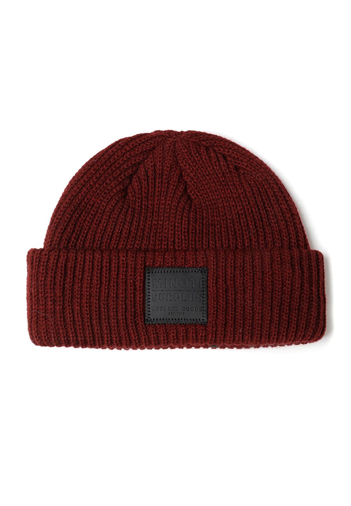 Detail of a knitted fisherman hat in dark red with a front badge.