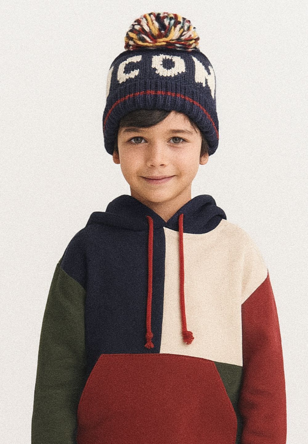Boys navy jacquard hat with pom pom, front view, features knitted wording.