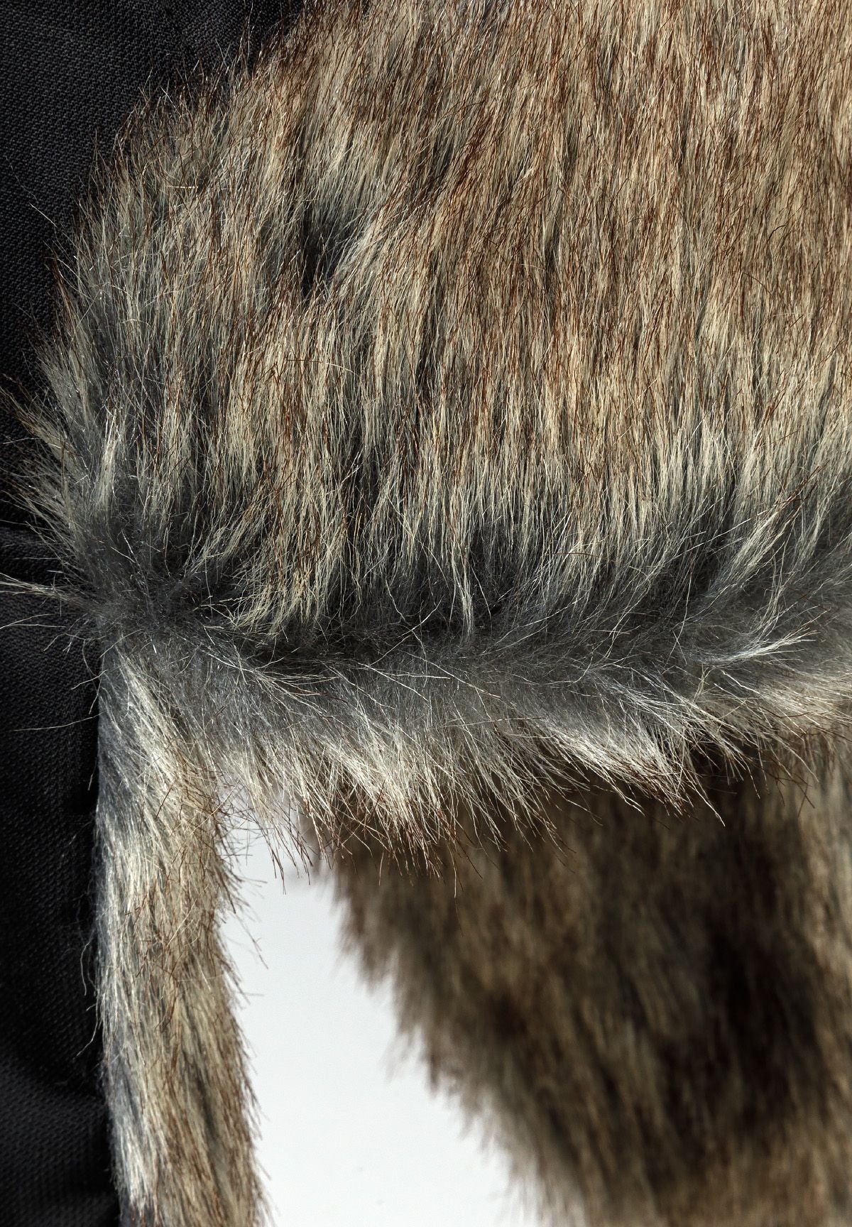 Detail of a unisex black trapper hat with faux fur lining.