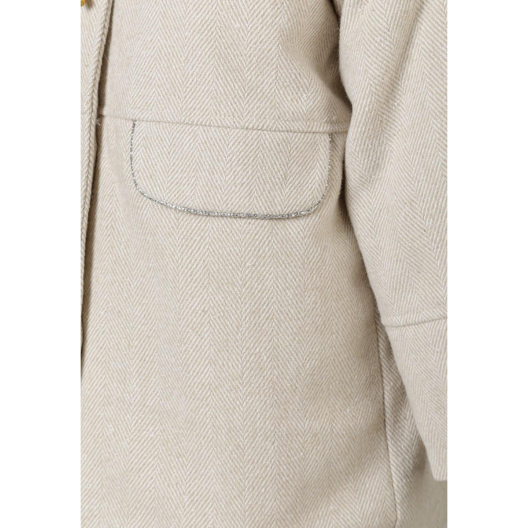 Close-up detail of grey wool blend coat showing herringbone weave texture, curved front patch pocket with topstitching and quality construction