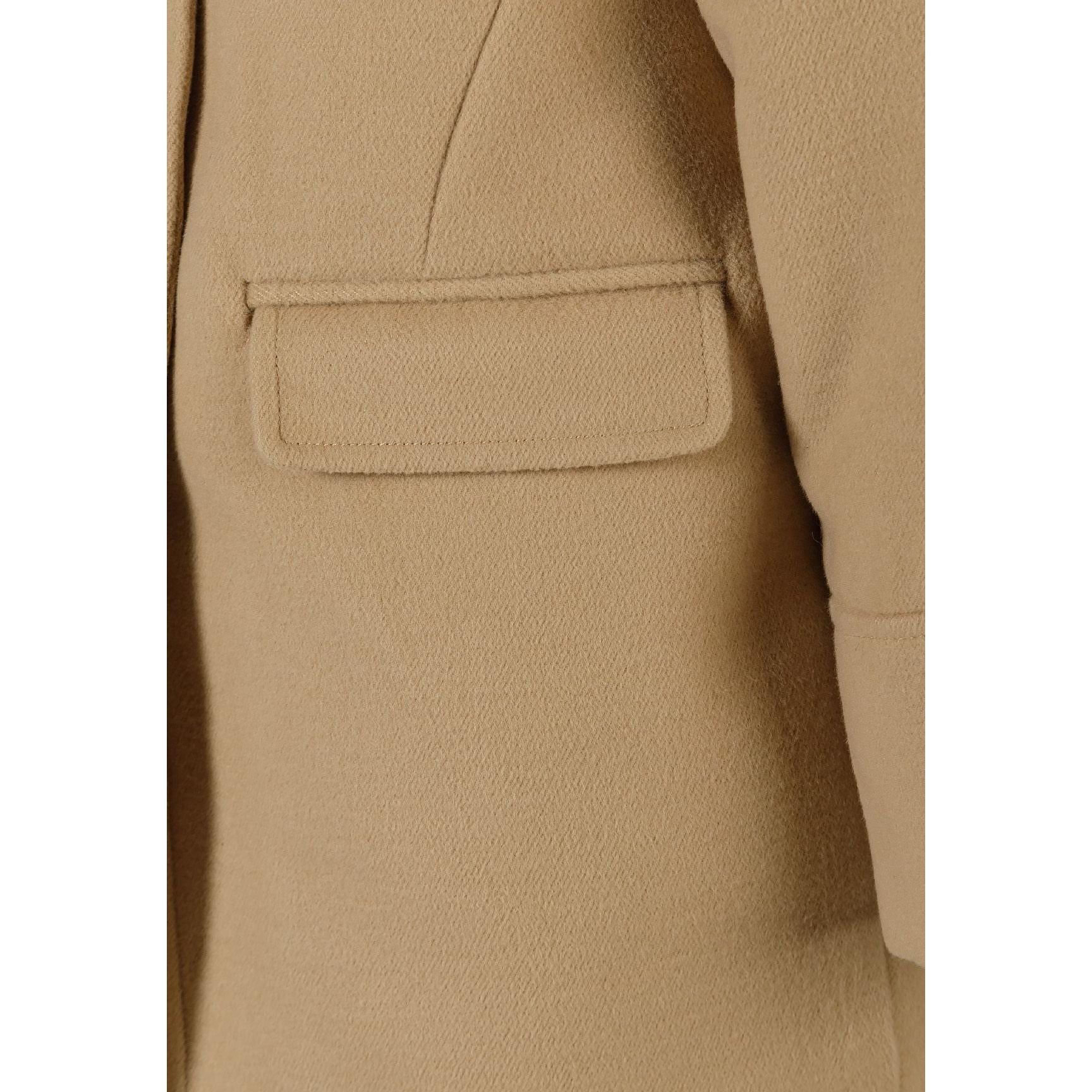 Close-up detail of beige padded coat showing fabric texture, front pocket construction and quality stitching