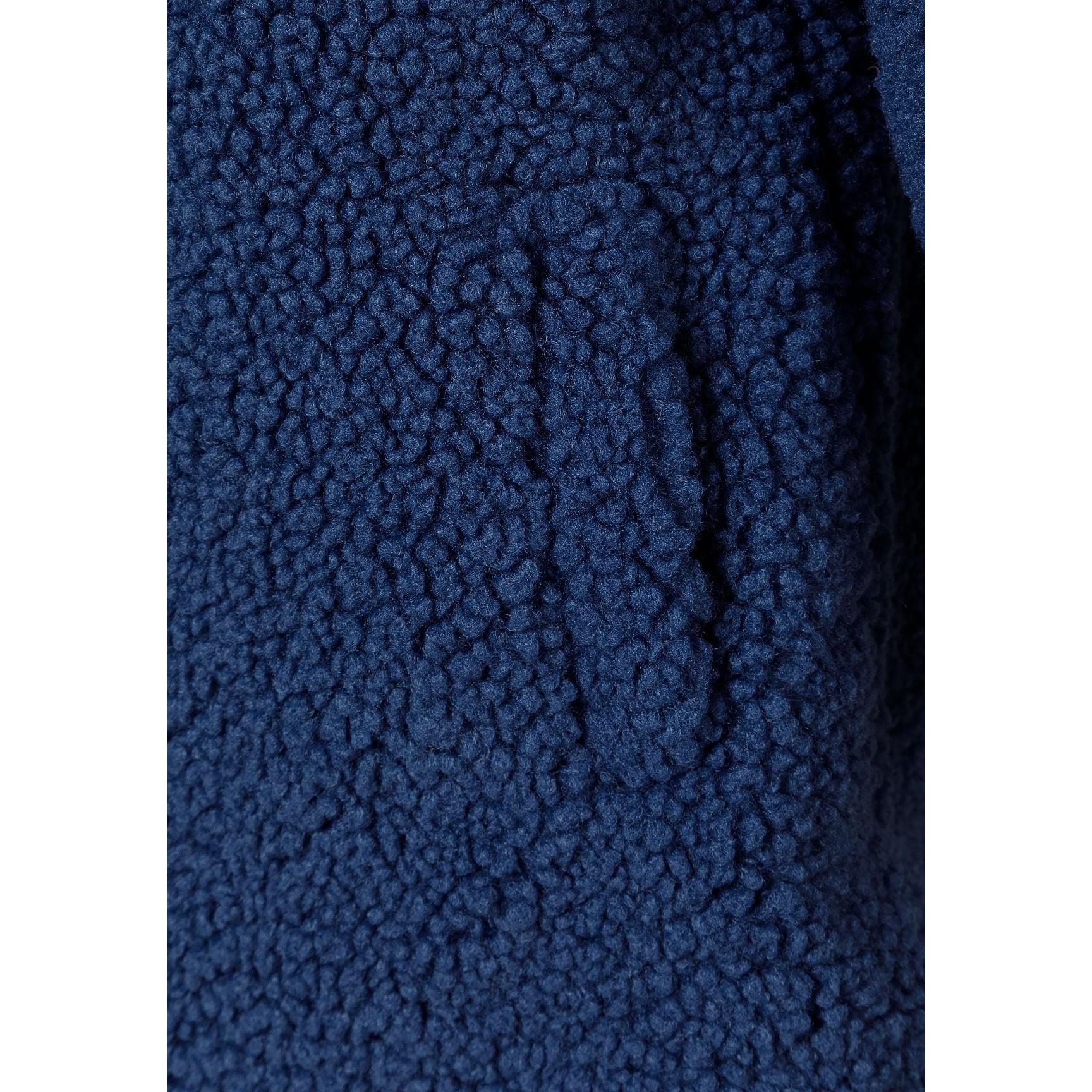 Close-up detail of navy boucle fabric texture showing the characteristic curly, nubby surface pattern