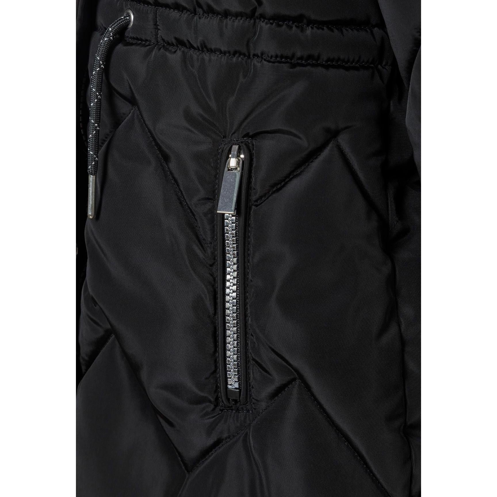 Close-up detail of black quilted parka showing faux fur hood trim, snap button closures and diamond quilting pattern texture
