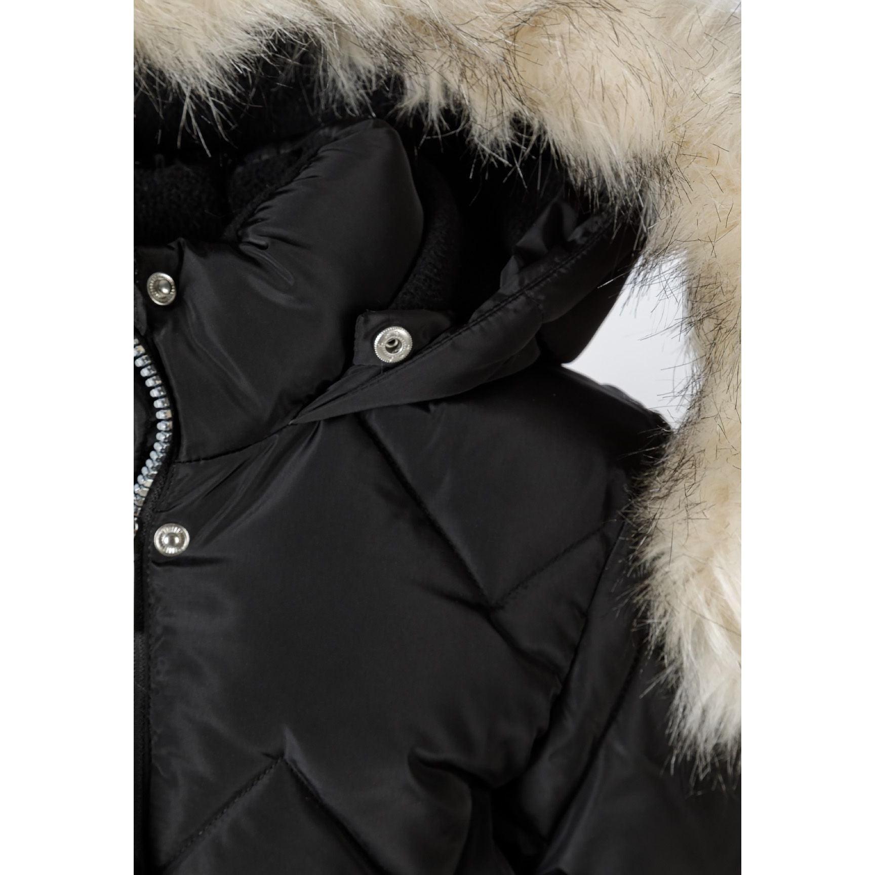 Close-up detail of black quilted parka showing faux fur hood trim, snap button closures and diamond quilting pattern texture