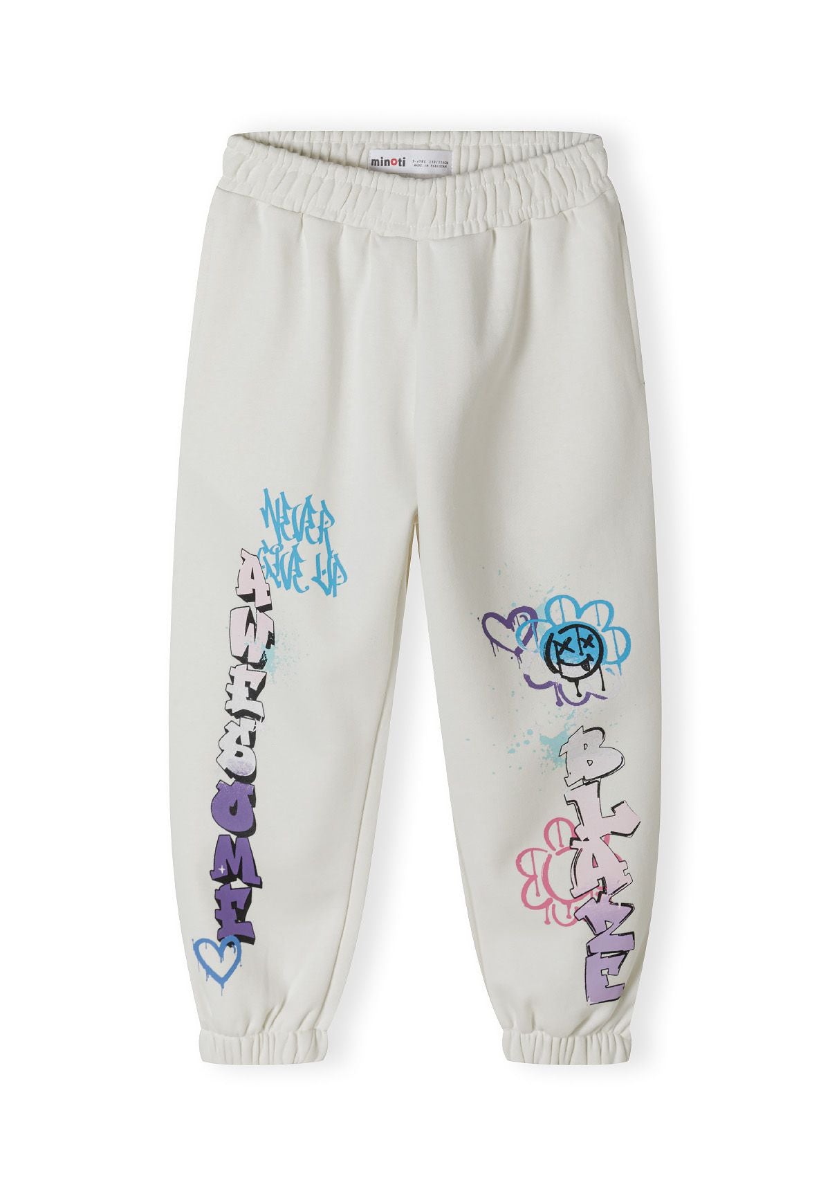 Detail of cream girls' tracksuit bottoms with printed graffiti designs and elasticated cuffs.