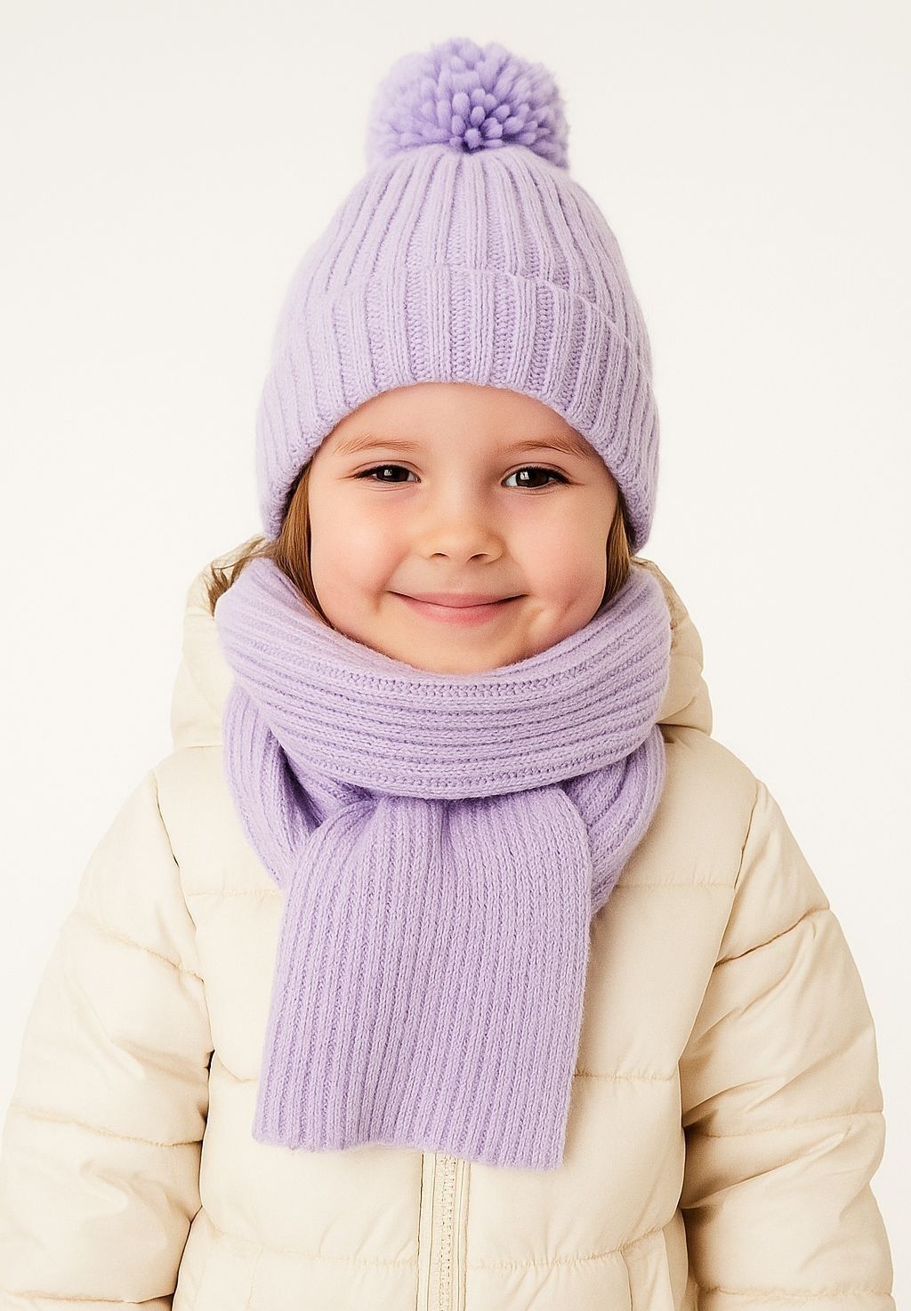 Close-up of a lilac knitted hat with pom pom and matching scarf for girls.