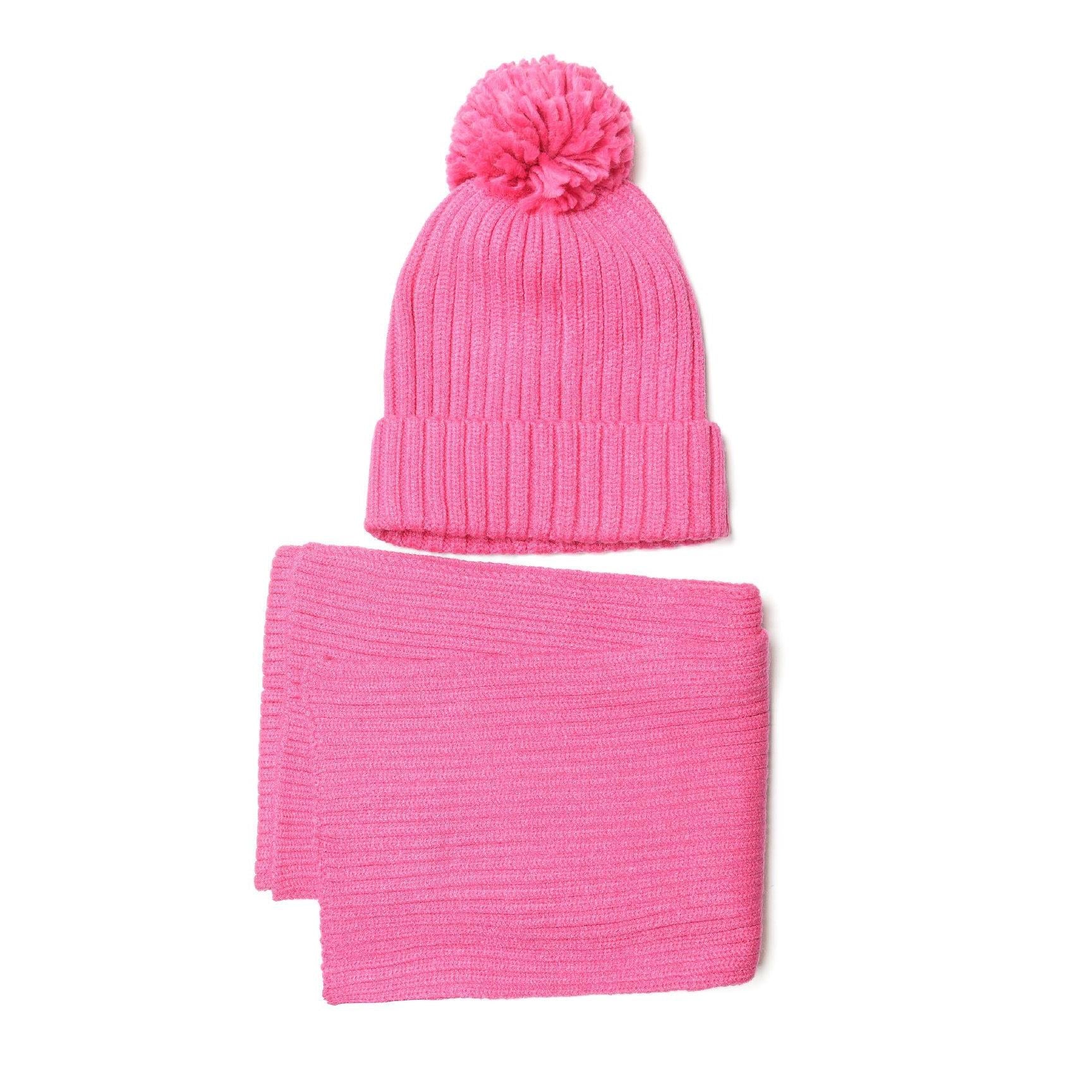 Close-up detail of pink ribbed knit beanie hat showing texture and fluffy pom pom against white background