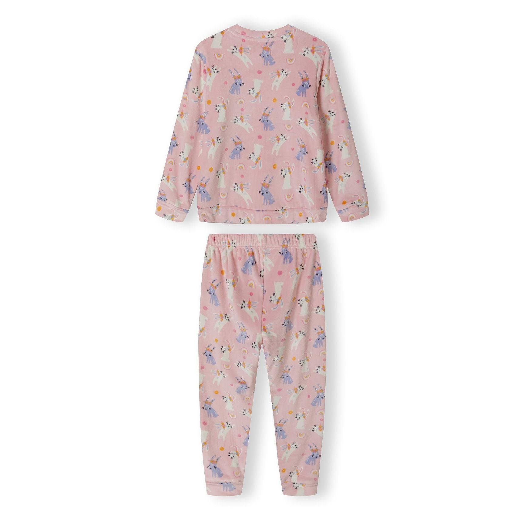 Close-up detail of pink velour fabric showing unicorn characters with rainbow and dot pattern