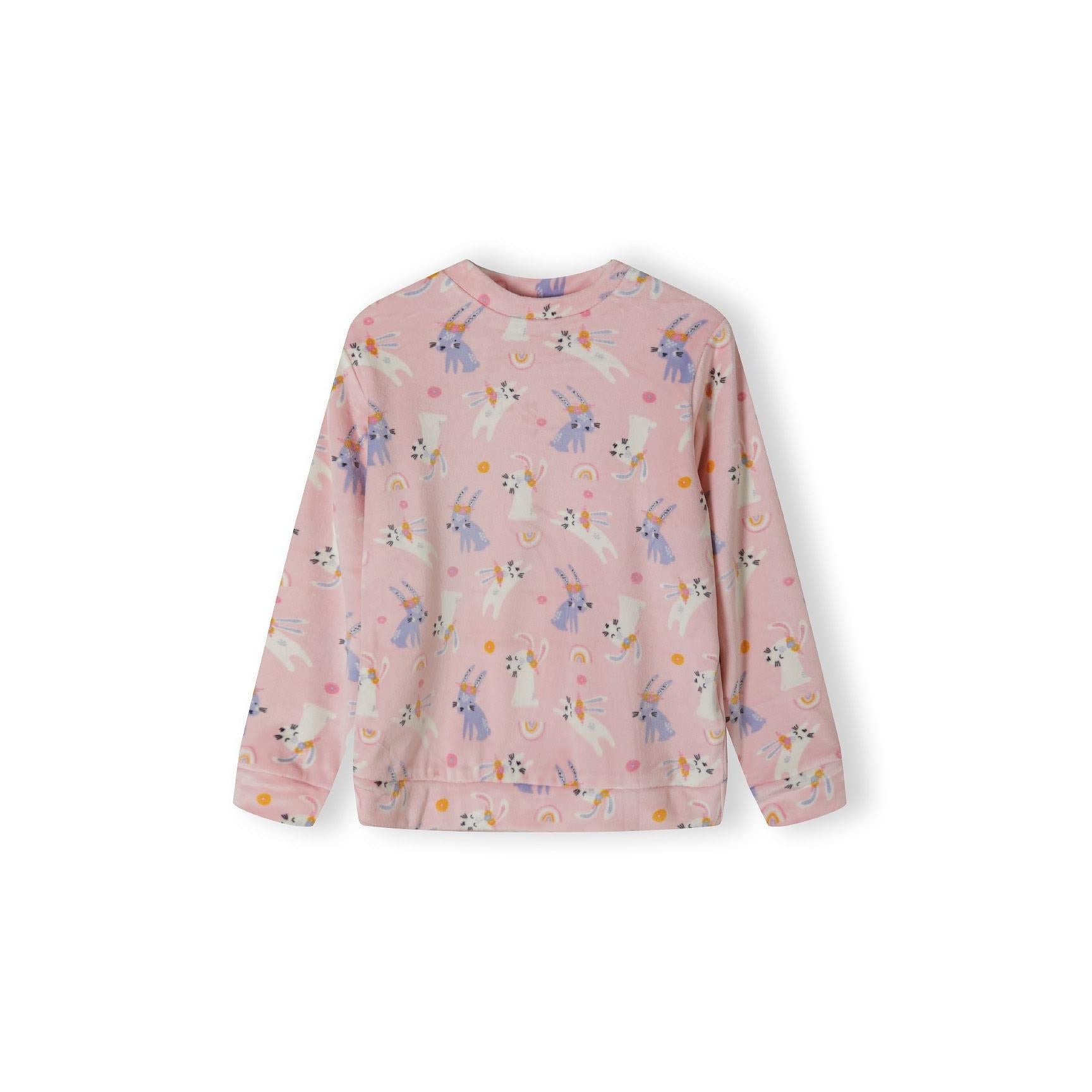 Close-up detail of pink velour fabric showing unicorn characters with rainbow and dot pattern