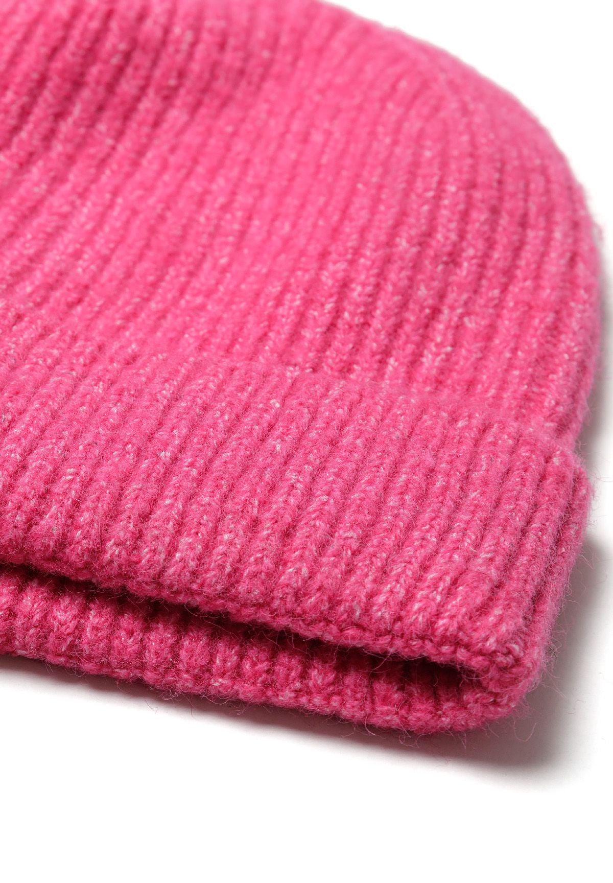 Close-up of a pink knitted beanie with ribbed edge and reflective detail.