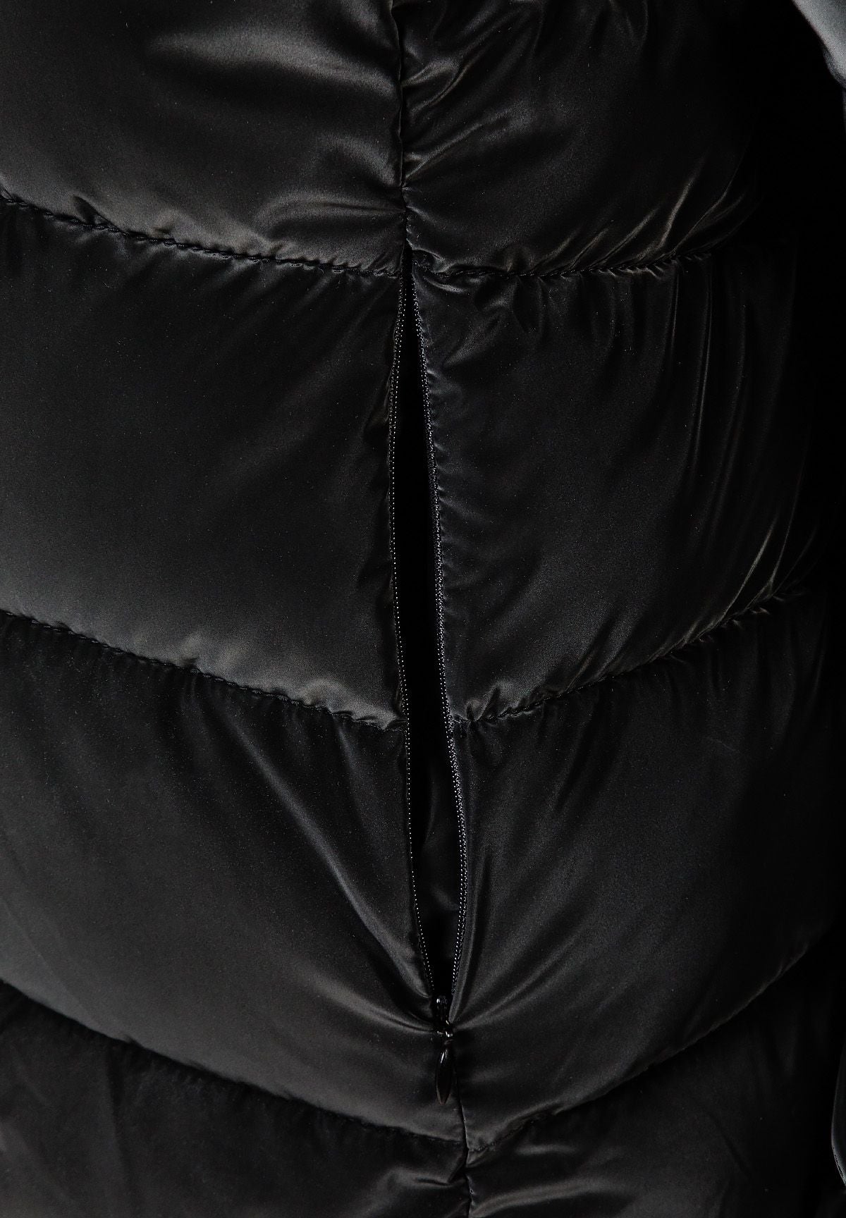 Close-up of a black padded jacket featuring a front zip and toggle details.