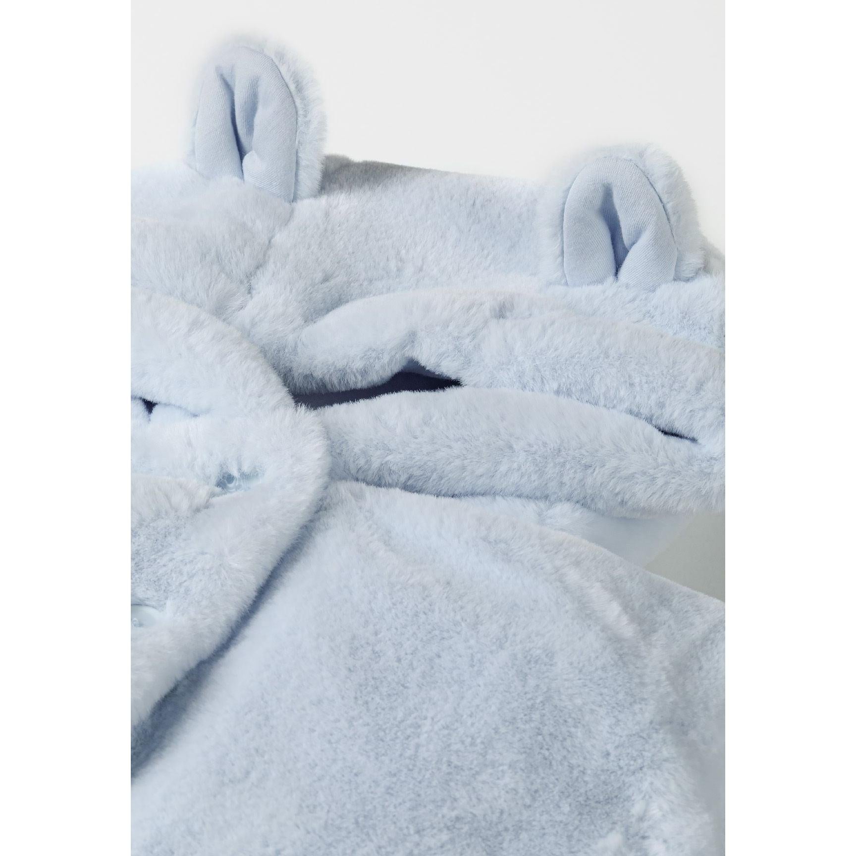 Close-up detail of light blue plush faux fur jacket showing soft fluffy texture and 3D ear construction on hood