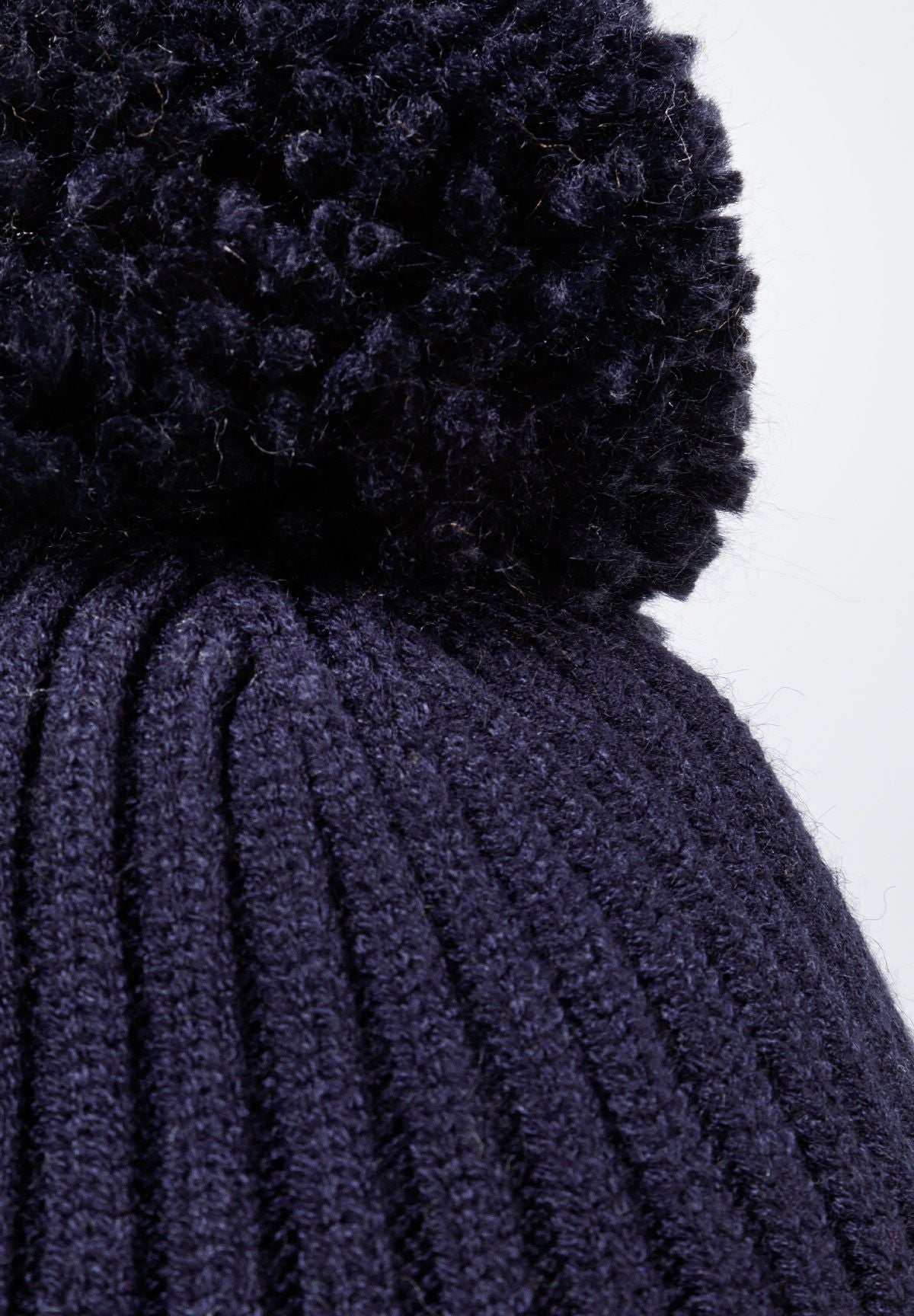 Navy bobble hat with ear flaps, pompom detail.