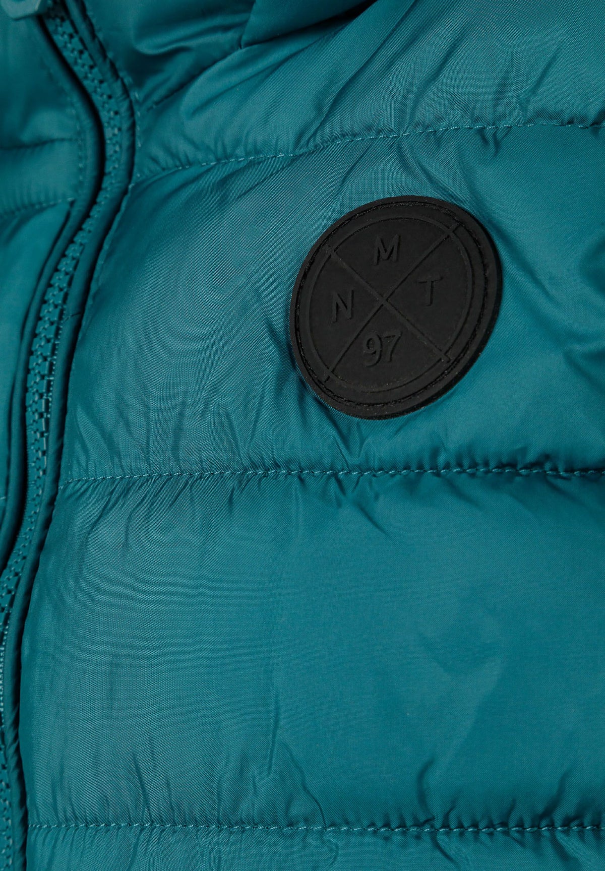 Teal padded gilet, badge detail.