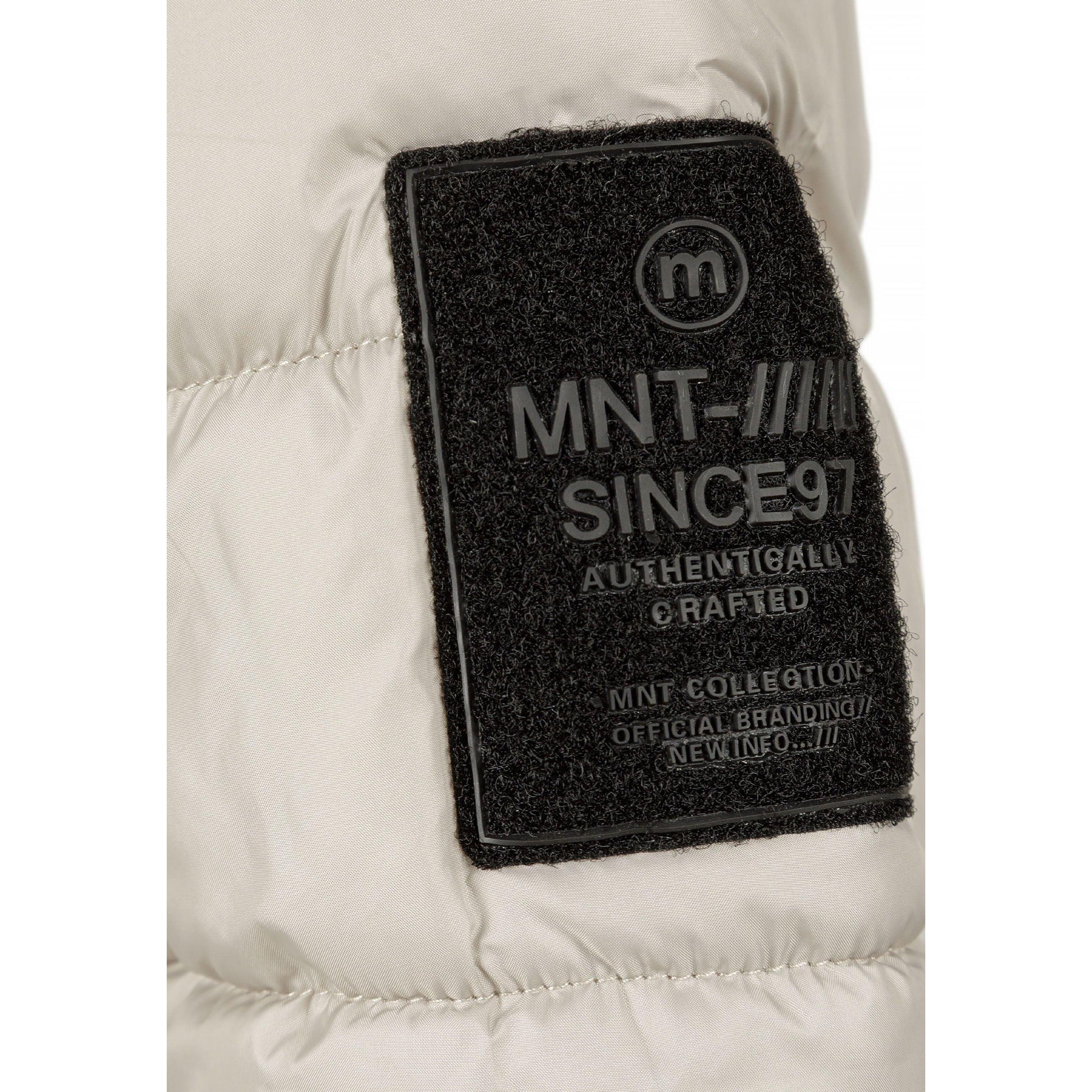 Close-up of black MNT patch on grey jacket sleeve showing brand details and authenticity markings