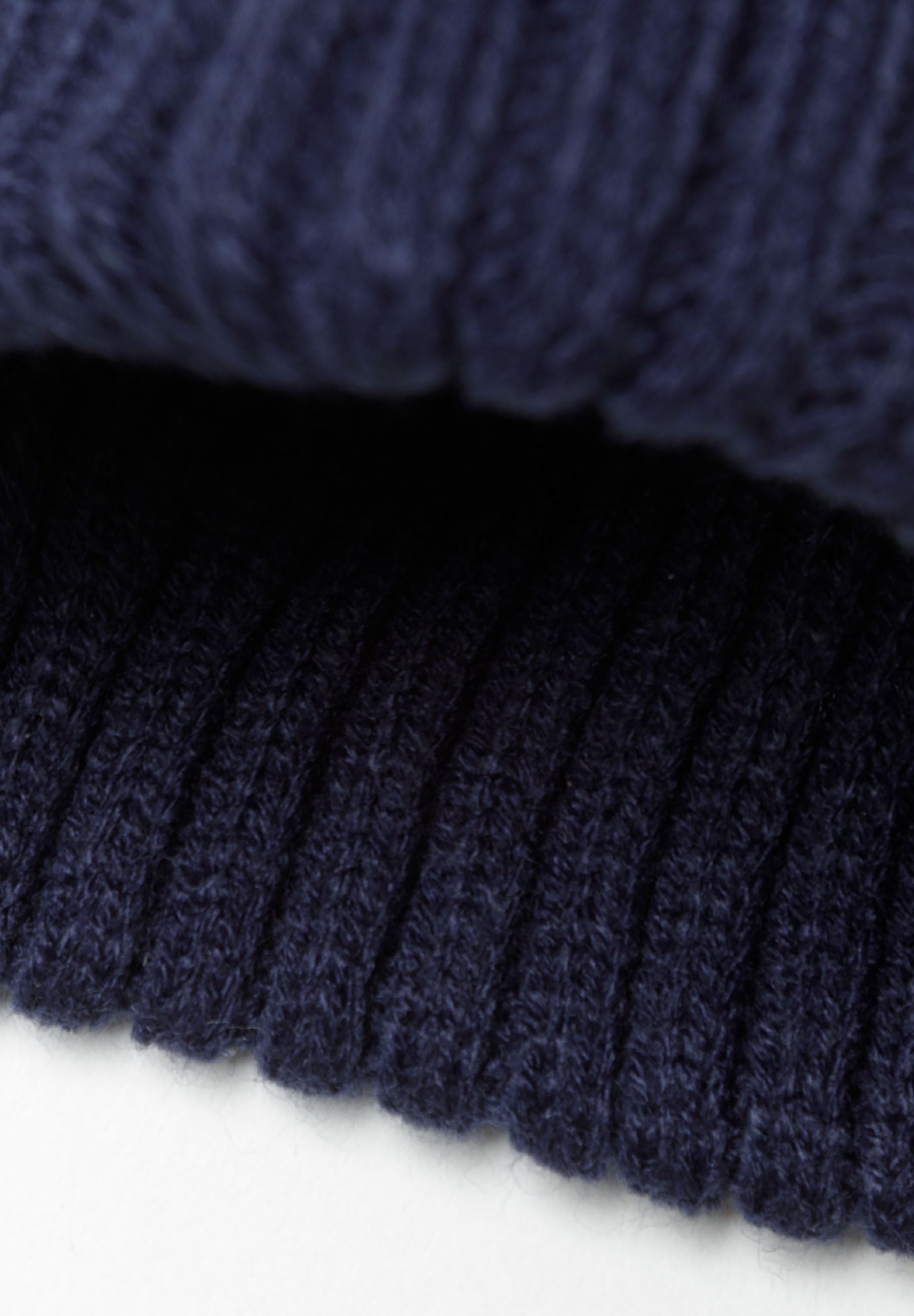 Detail of navy ribbed knit fabric from boys snood and beanie set.