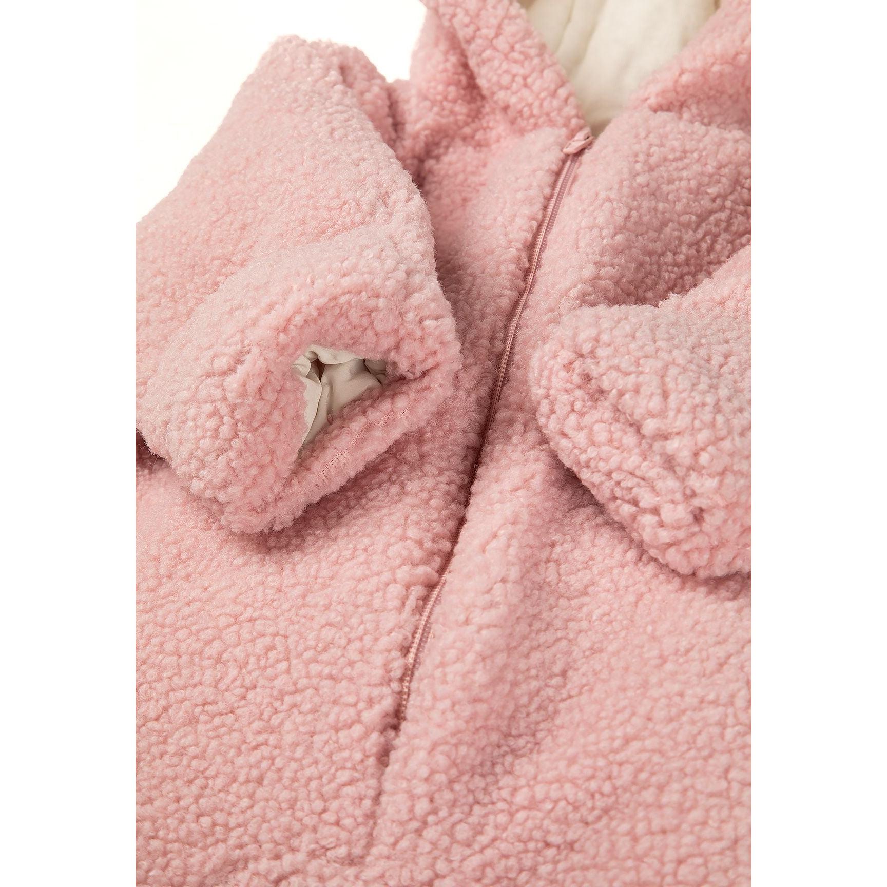Detail shot of pink sherpa fabric texture and zip closure construction showing quality craftsmanship of the baby snowsuit