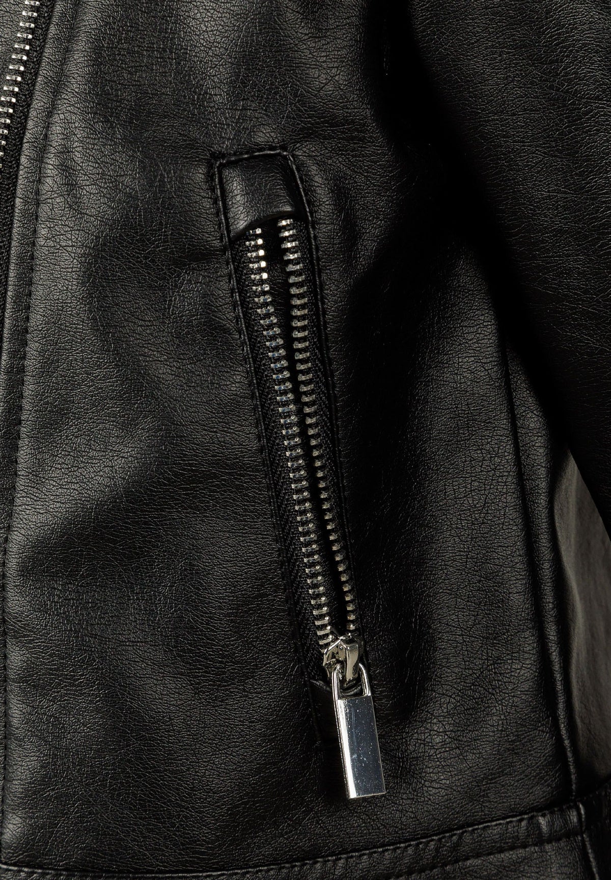 Close-up of a vertical silver pocket zip on a textured black biker jacket.