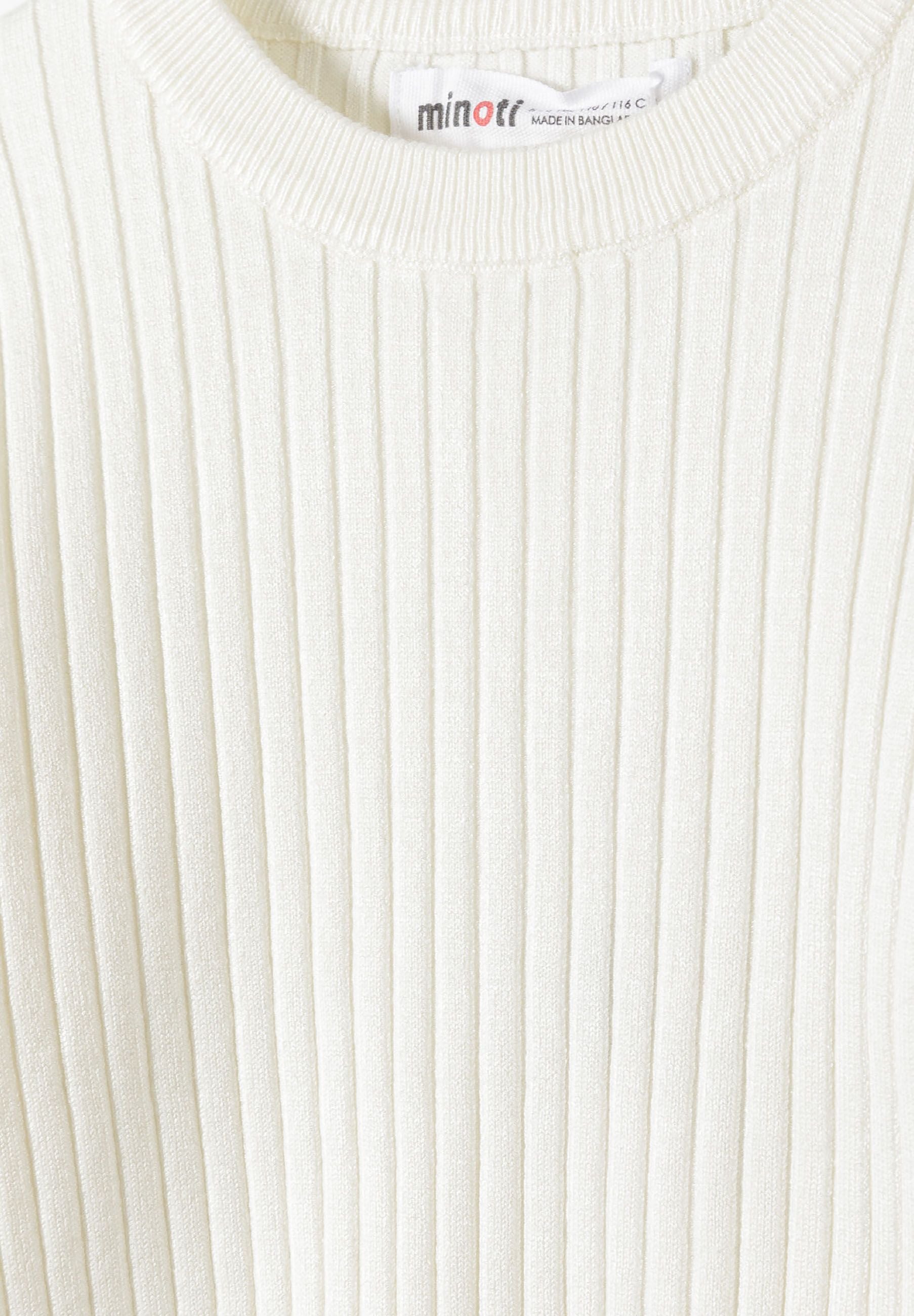 Detail of a girls' white ribbed long sleeve jumper with frilled cuffs.