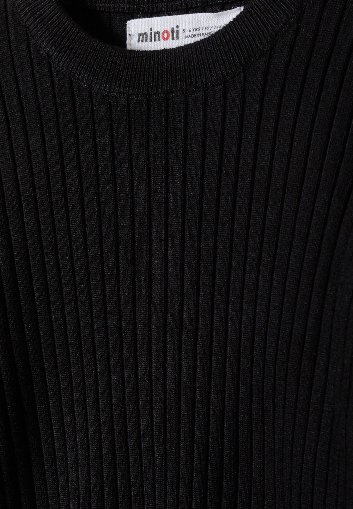 Close-up of black jumper's raised vertical rib knit and crew neckline.