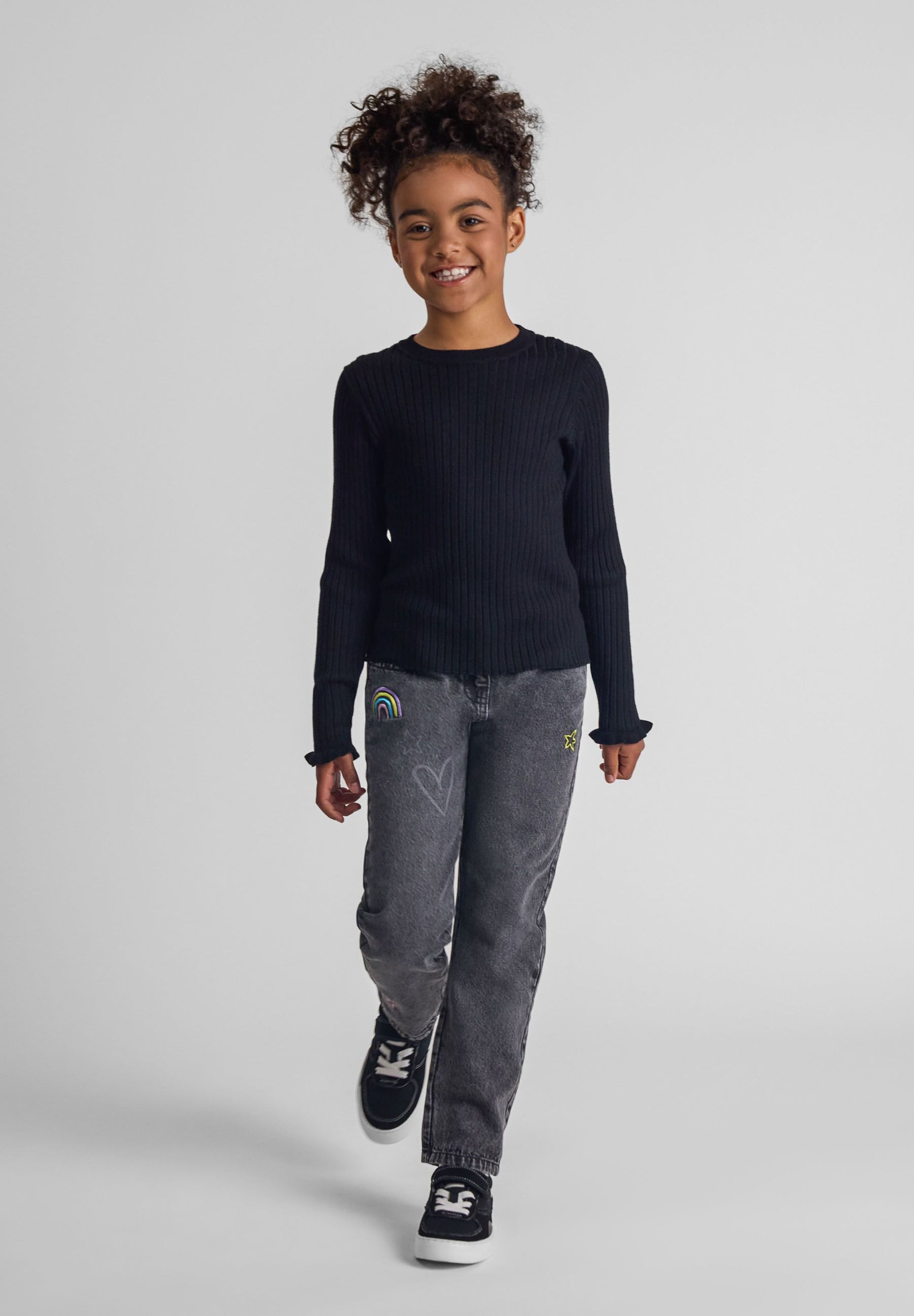 Girls black ribbed long sleeve jumper with frill cuffs, front view.