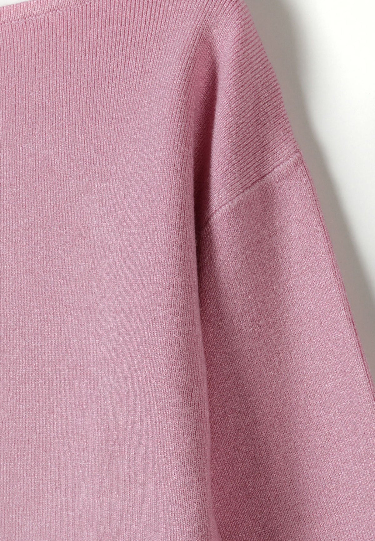 Close-up of pink jumper's fine knit and dropped shoulder seam.
