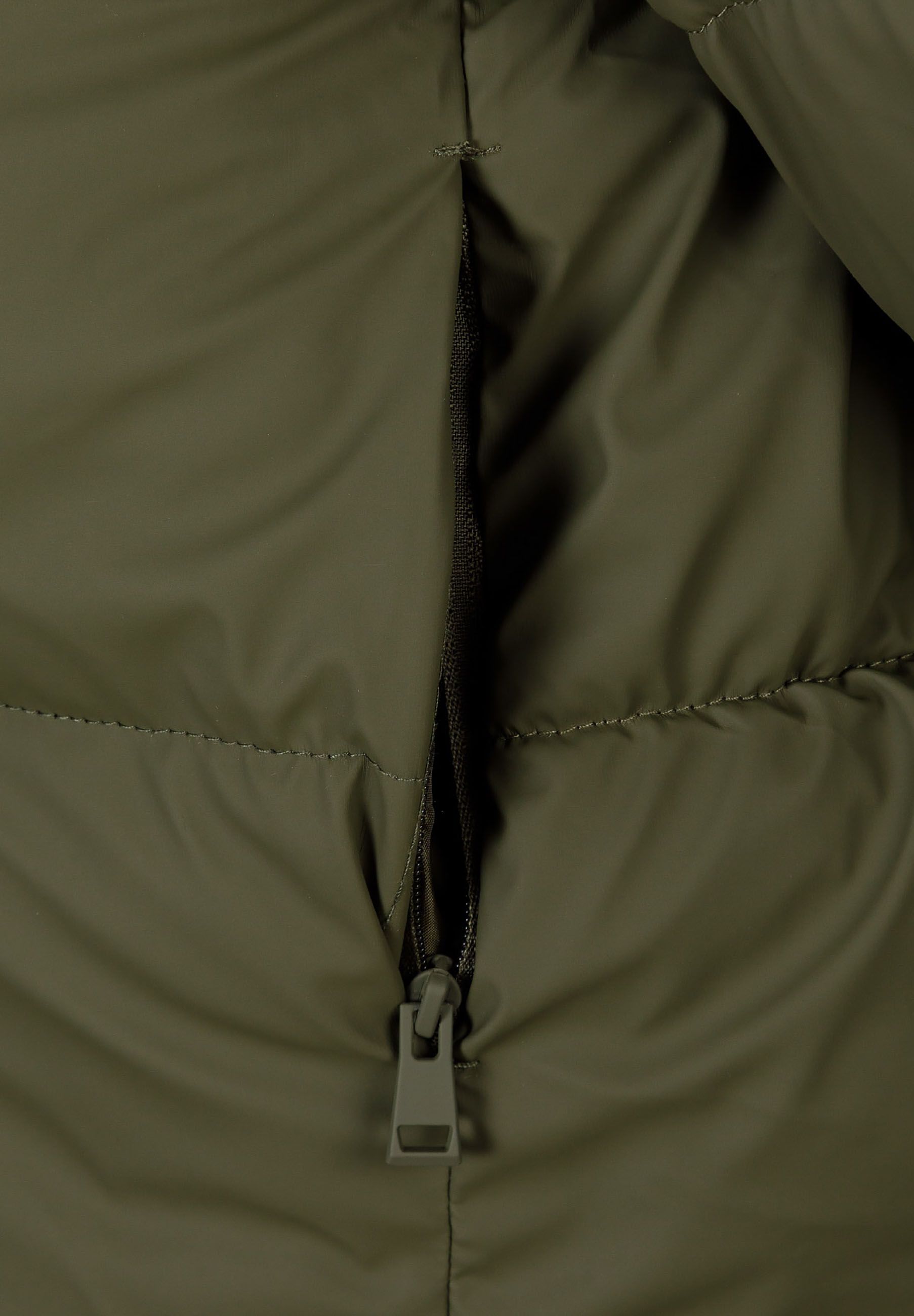 Detail of a khaki short quilted jacket with a full-length zipper.