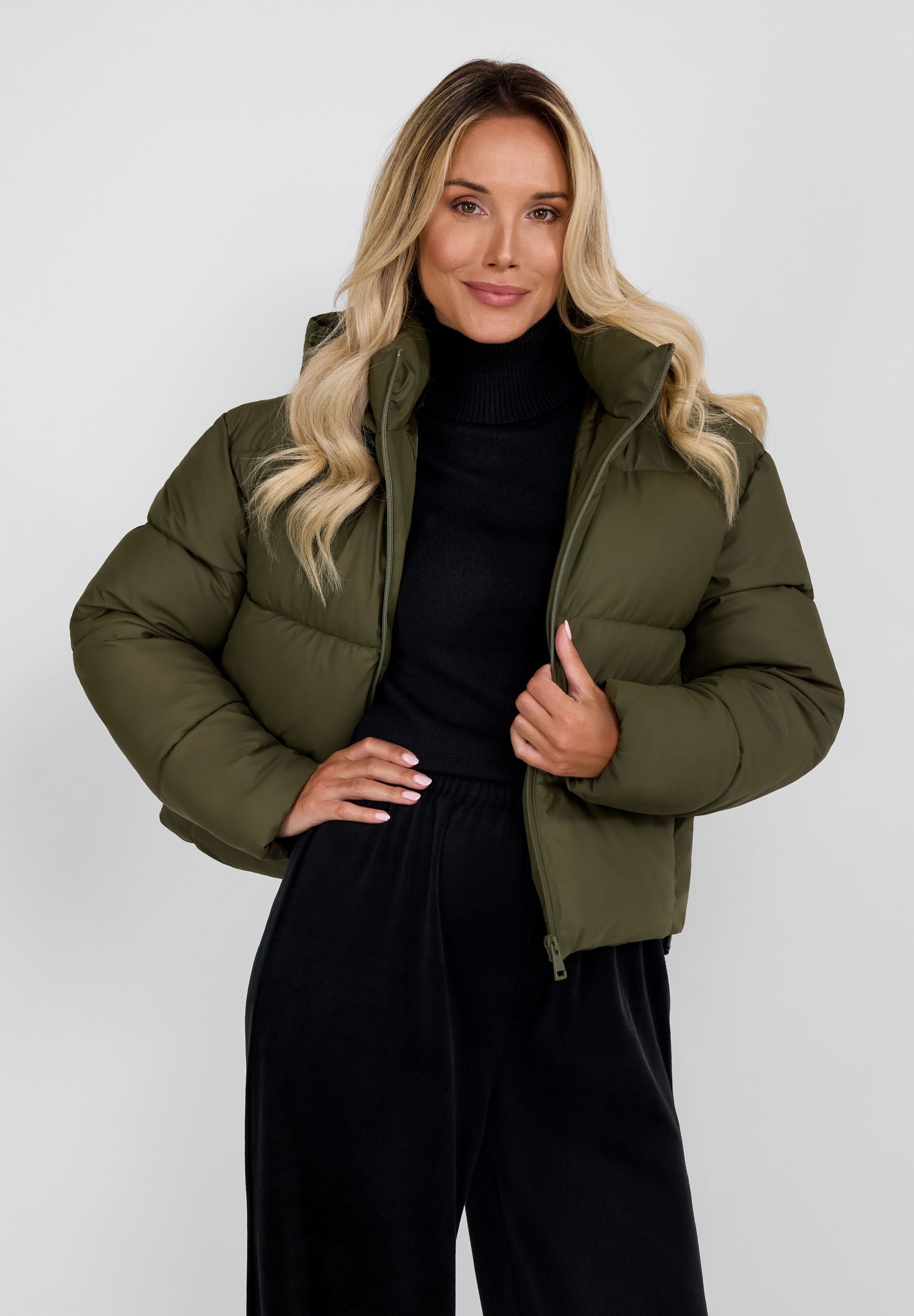 Women short quilted jacket in khaki with a high collar and hood, front view.