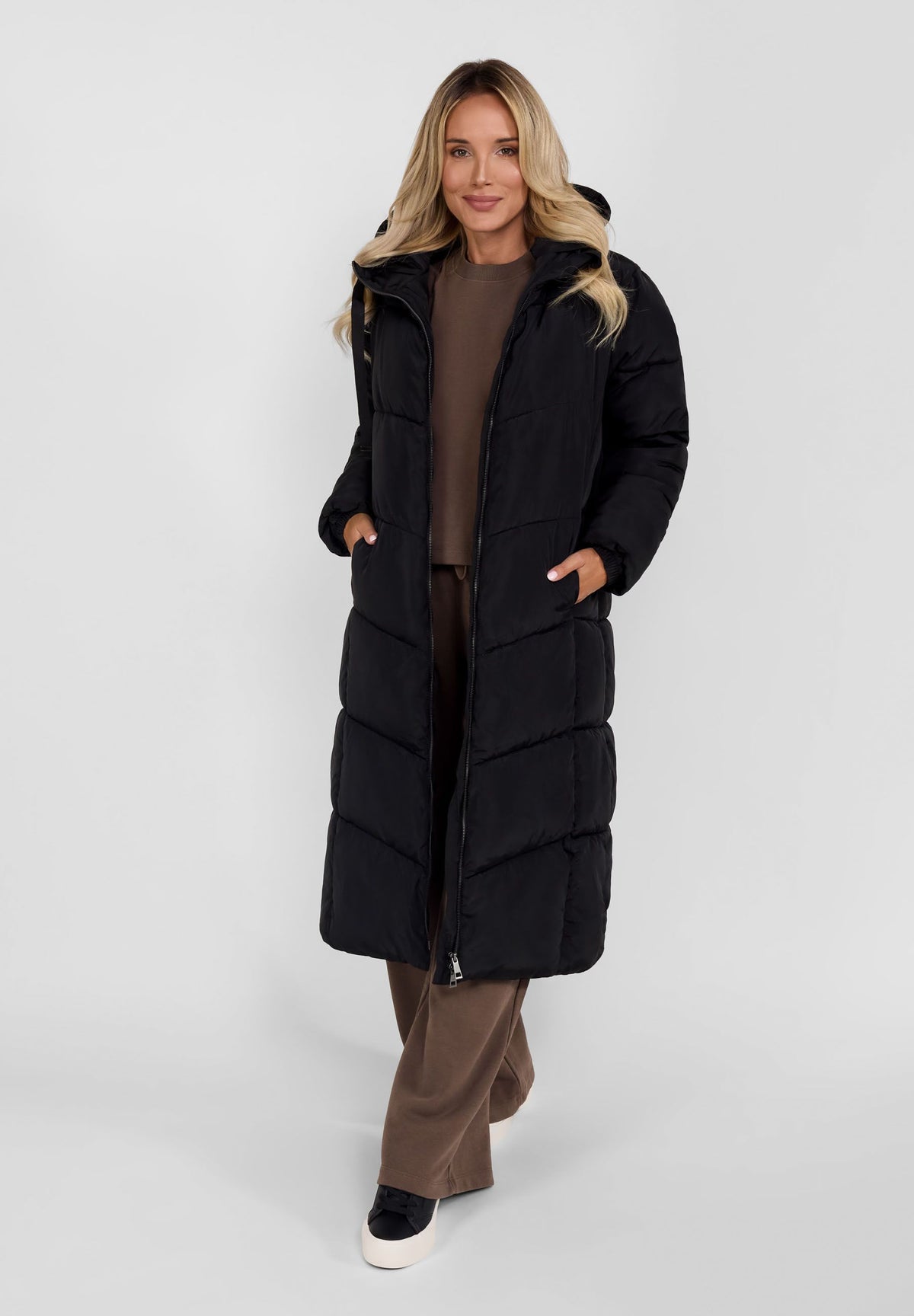 Women's black long puffer coat, shown worn.