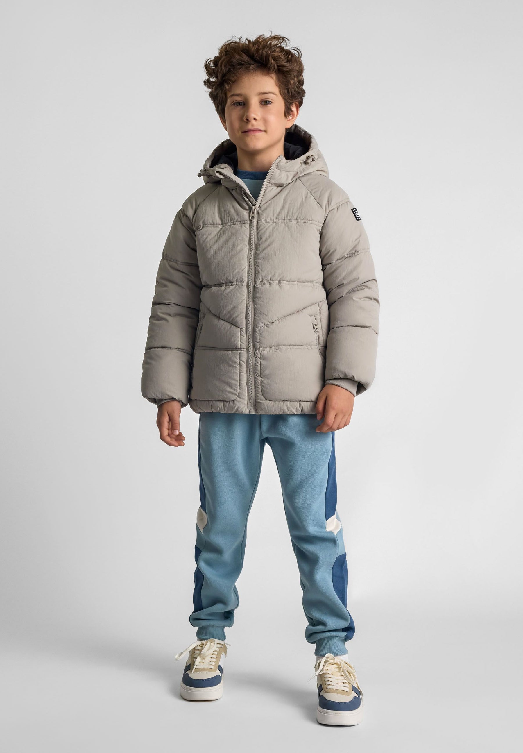 Boys quilted jacket in grey, front view with hood and zip pockets.