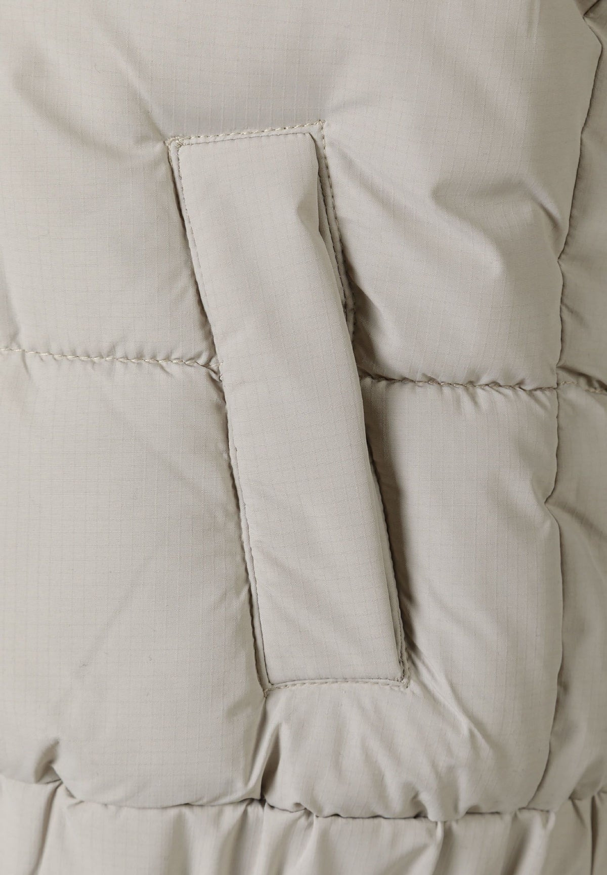 Boys' ripstop padded gilet with hood in stone, close-up of the vertical welt pocket