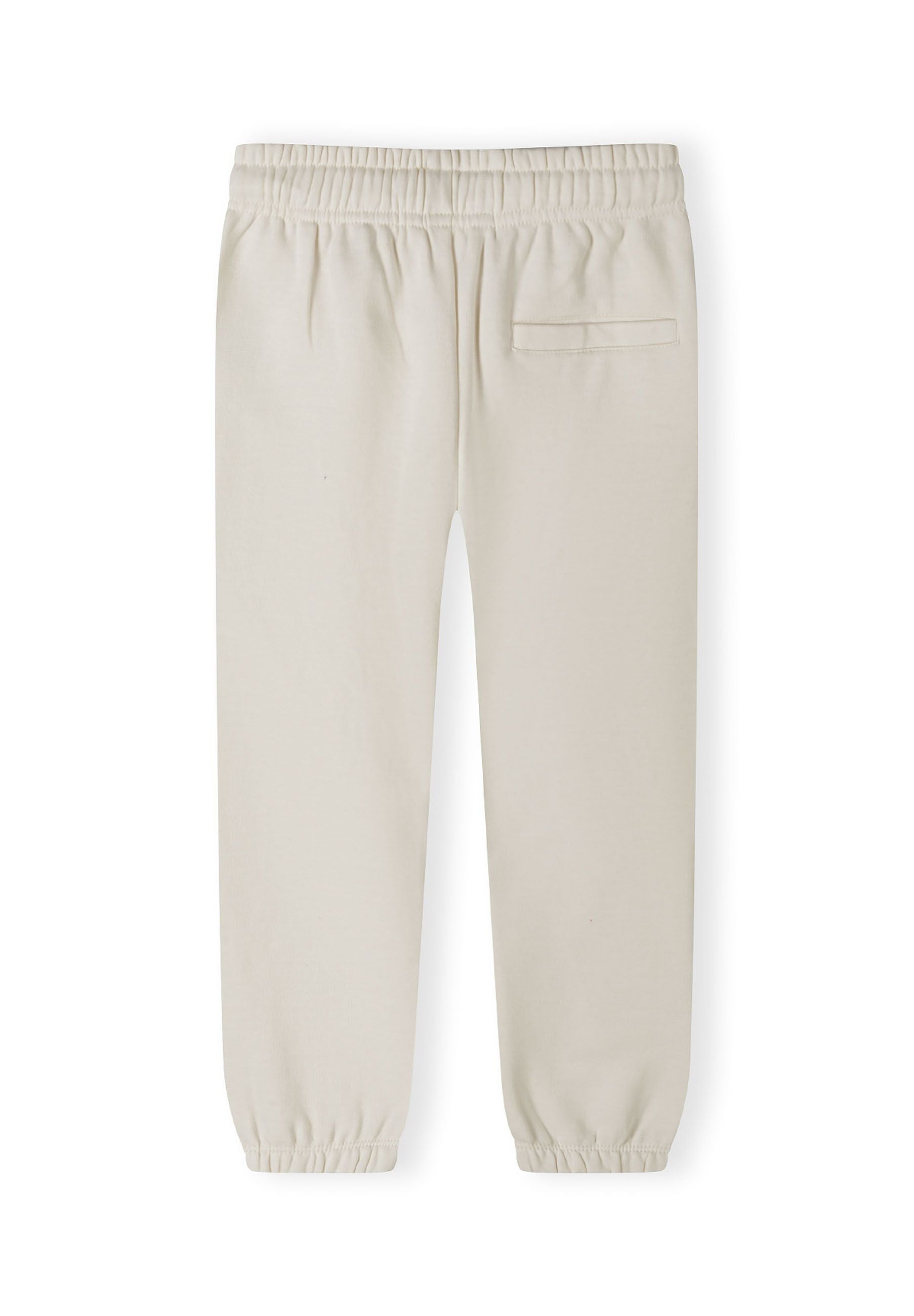 Detail of cream jogger trousers with elasticated waistband and ribbed cuffs.
