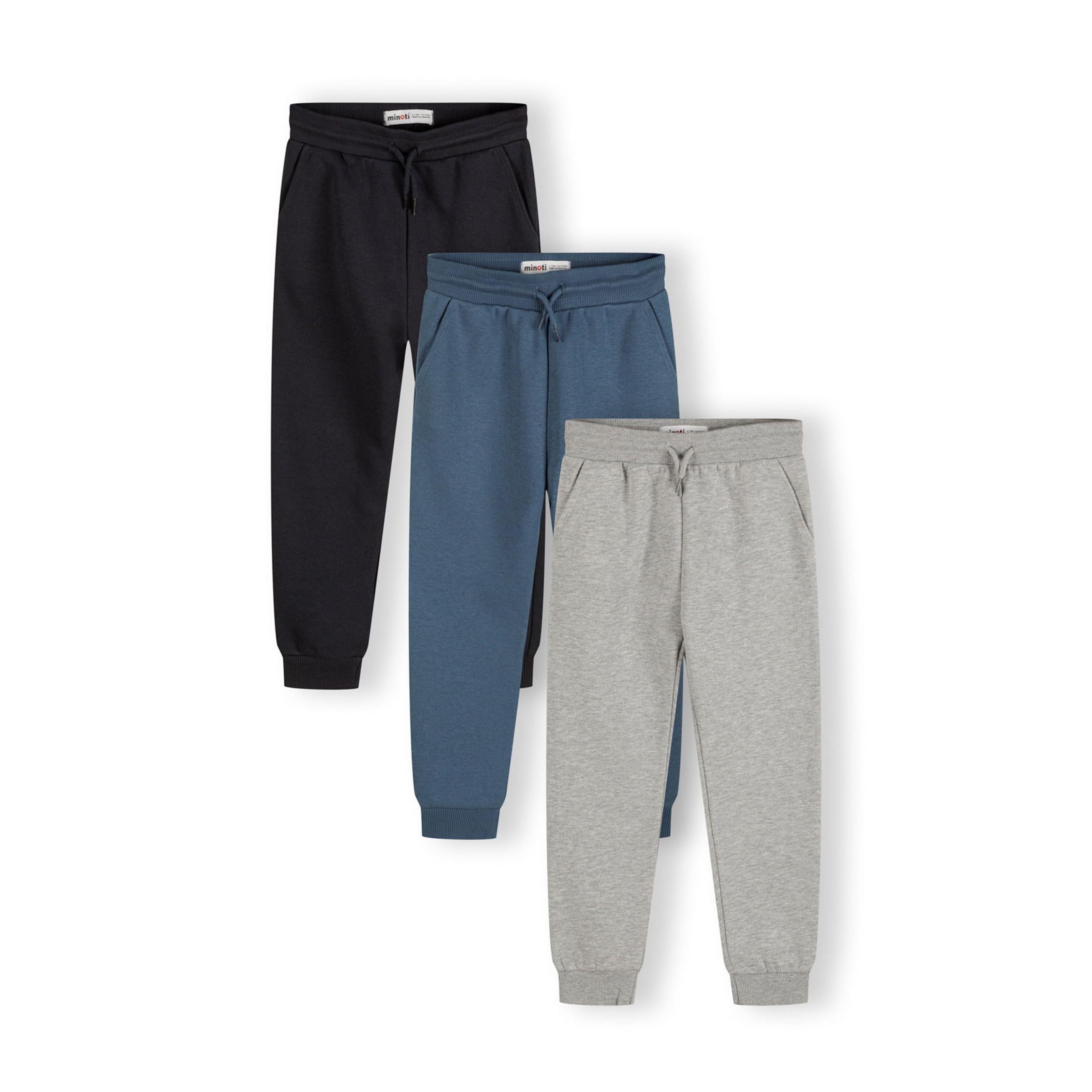 Three children's sweatpants in black, blue and grey arranged in a fan layout against white background showing drawstring waists and ribbed ankle cuffs